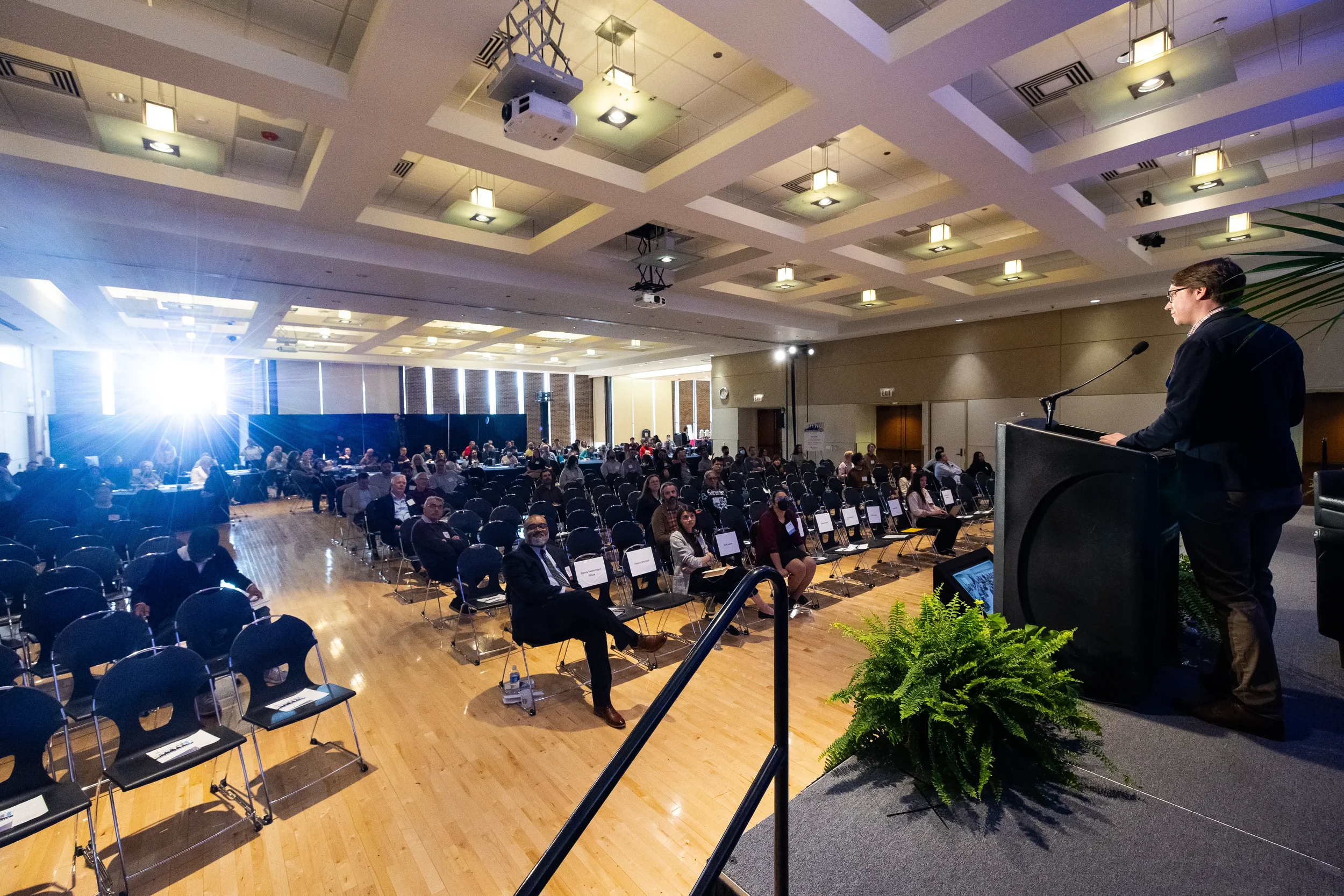 Speaker addresses seated audience from podium in wide ballroom view at Orlando corporate conference
