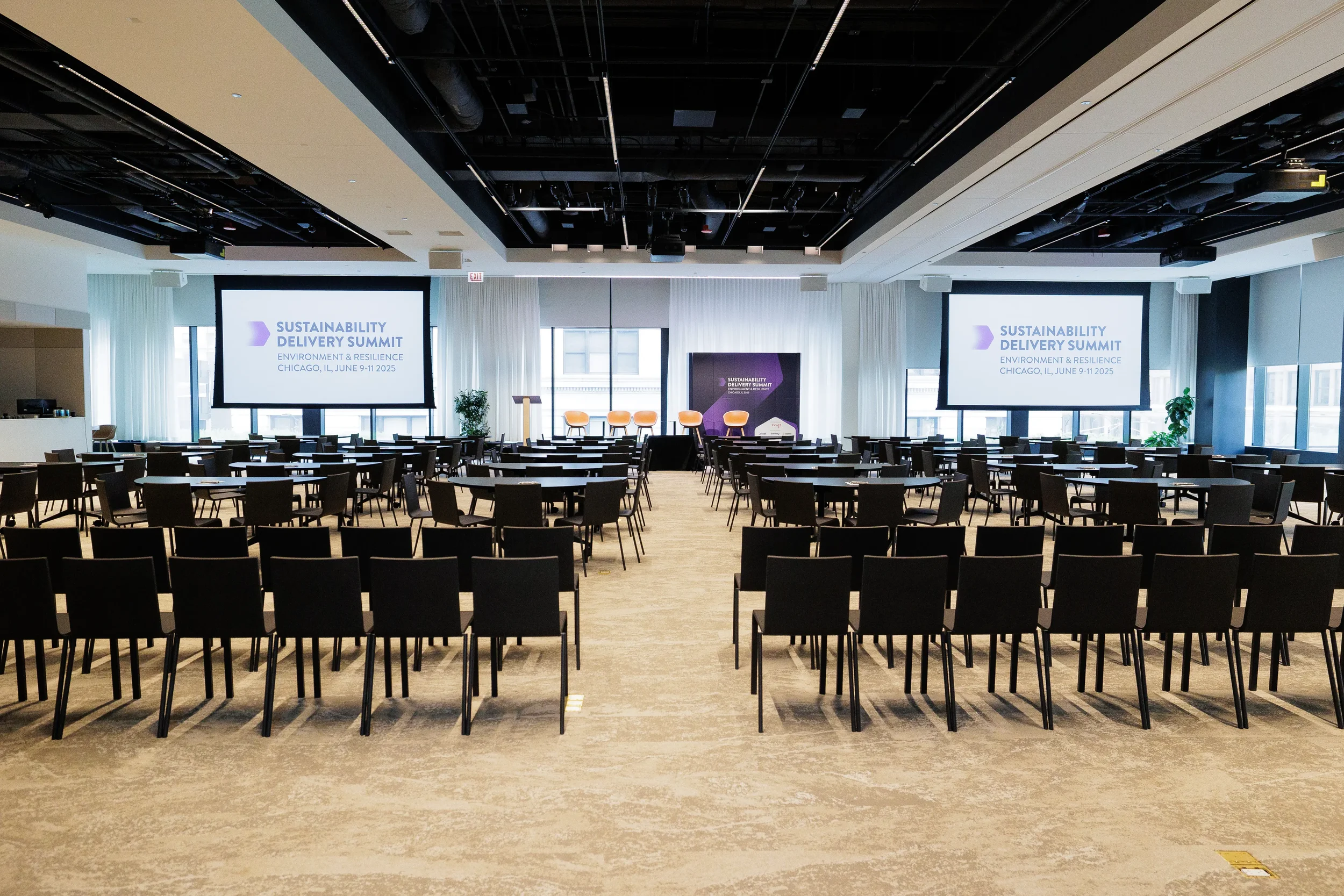 Conference hall set with rows of seating and dual screens ahead of Chicago industry summit