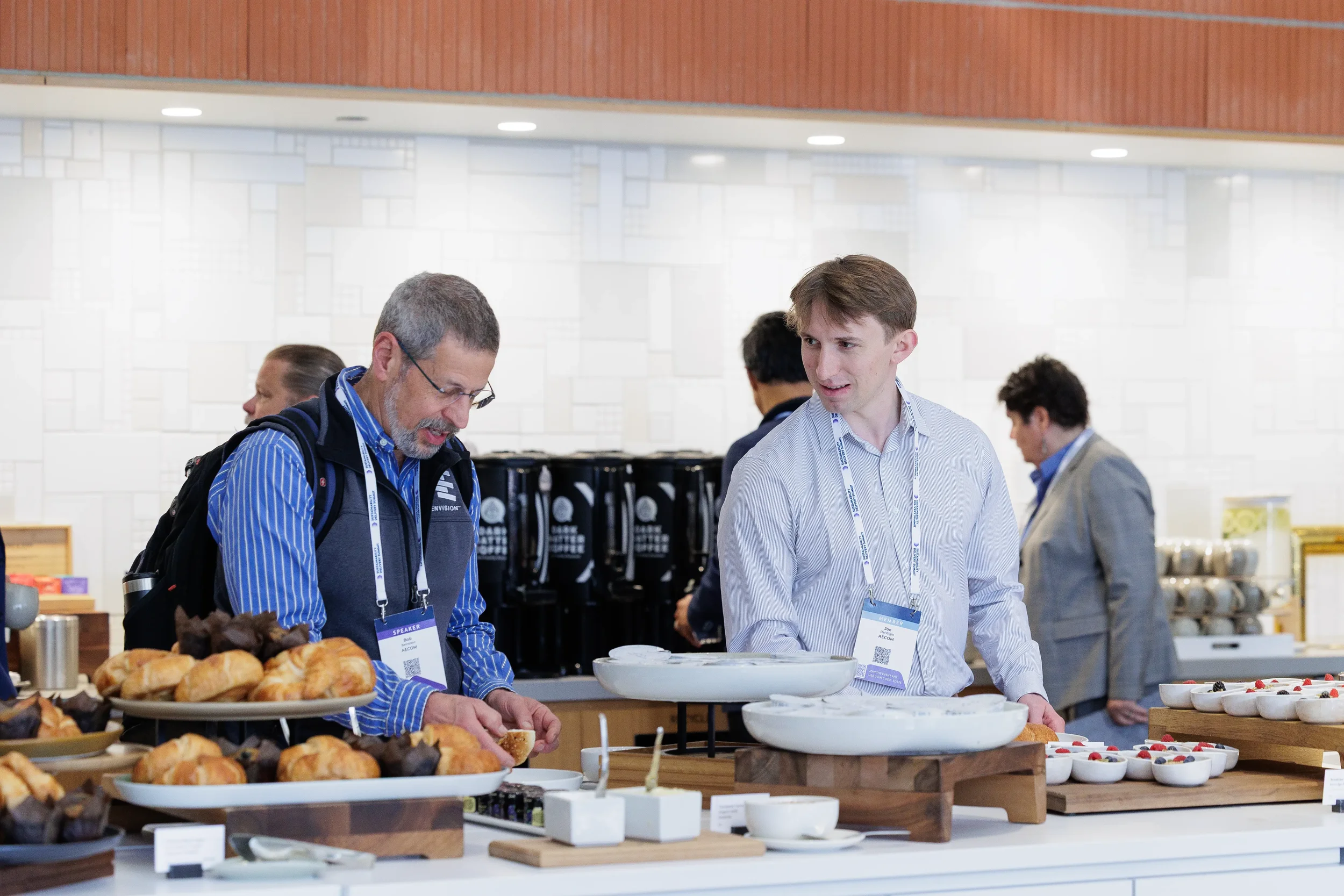 Attendees converse over breakfast buffet with pastries during Chicago corporate conference