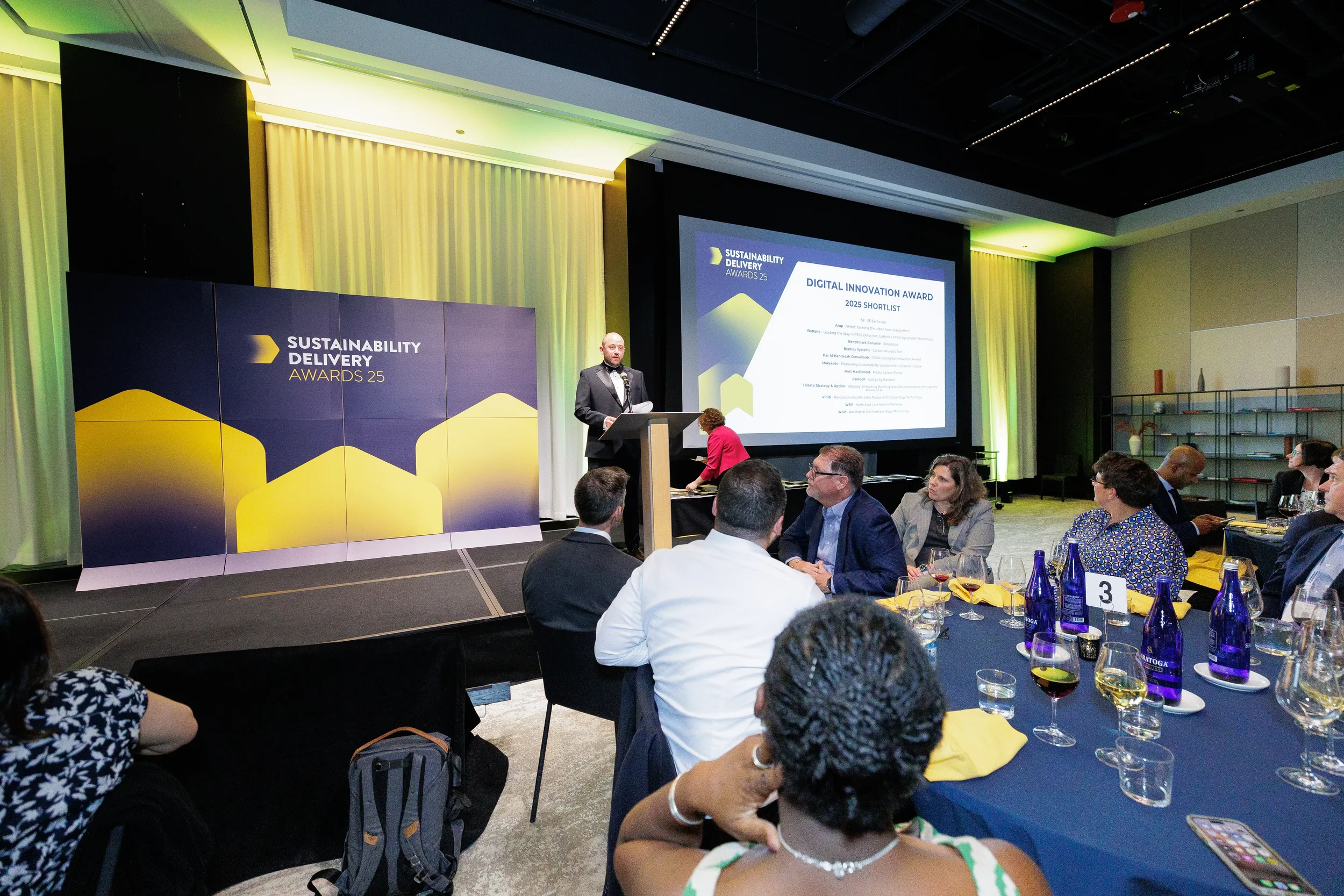 Host presents award shortlist from podium to seated guests at Chicago corporate awards ceremony