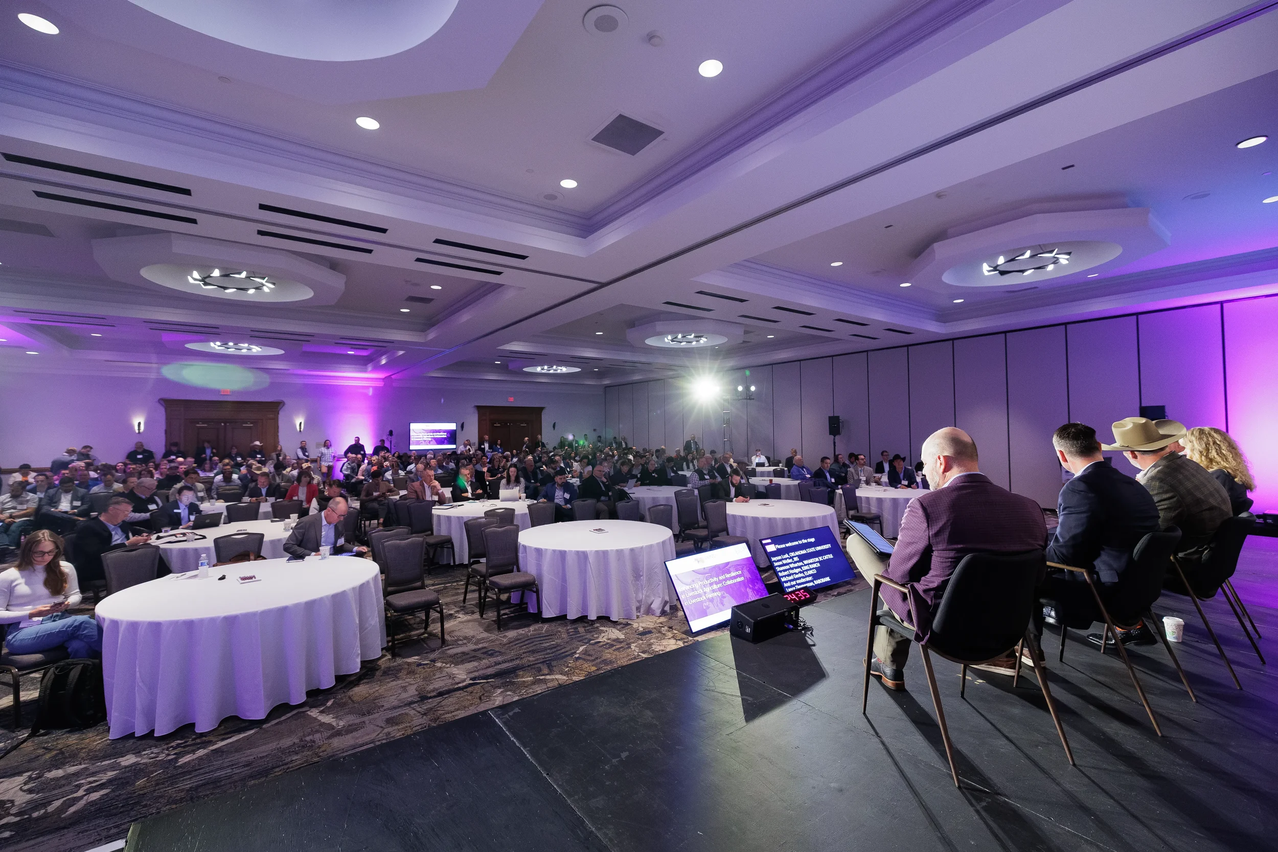 Wide view of ballroom audience and panel discussion on stage at Chicago industry conference