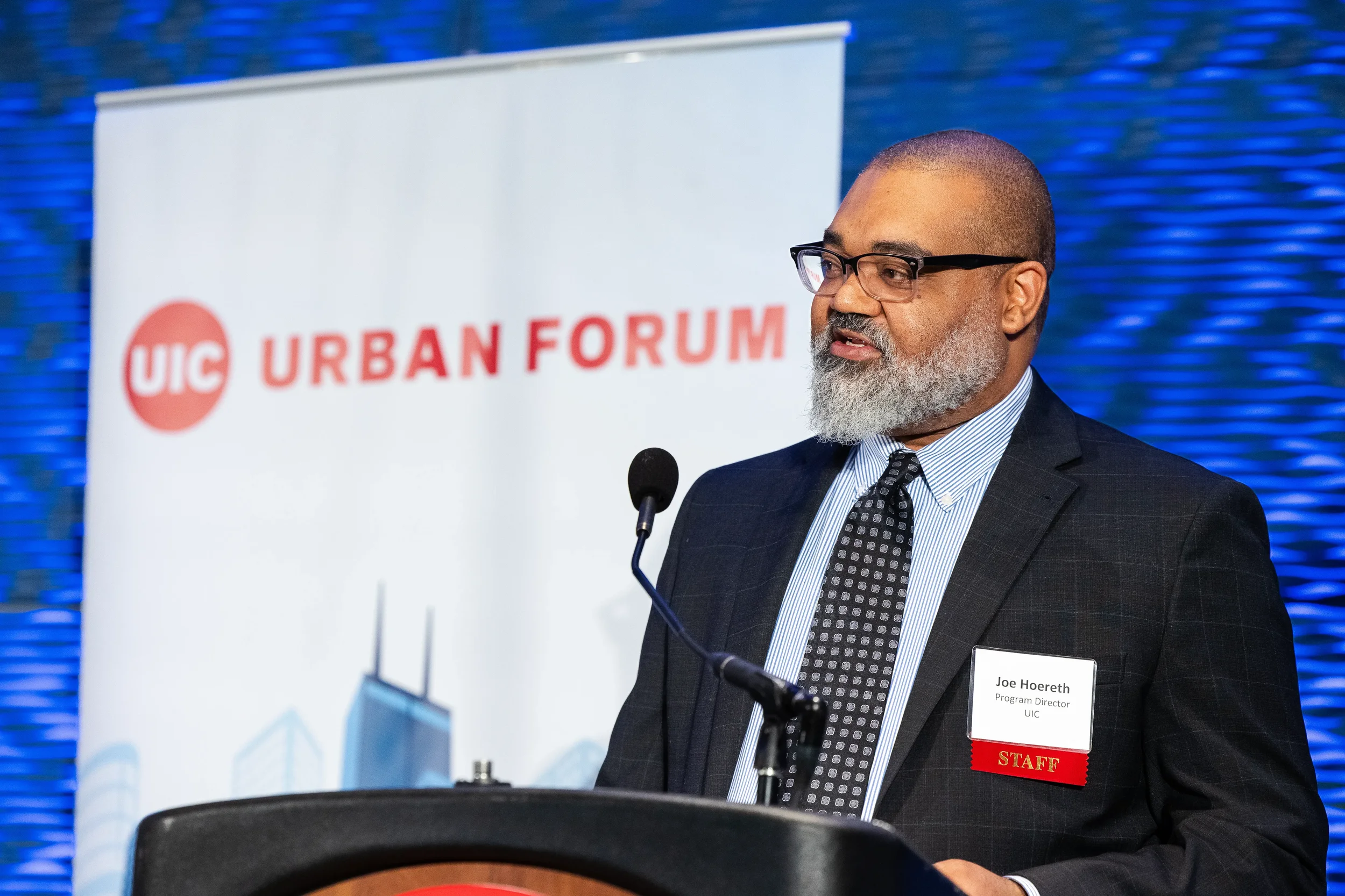 Speaker addresses audience from podium beside Urban Forum banner at Chicago industry conference