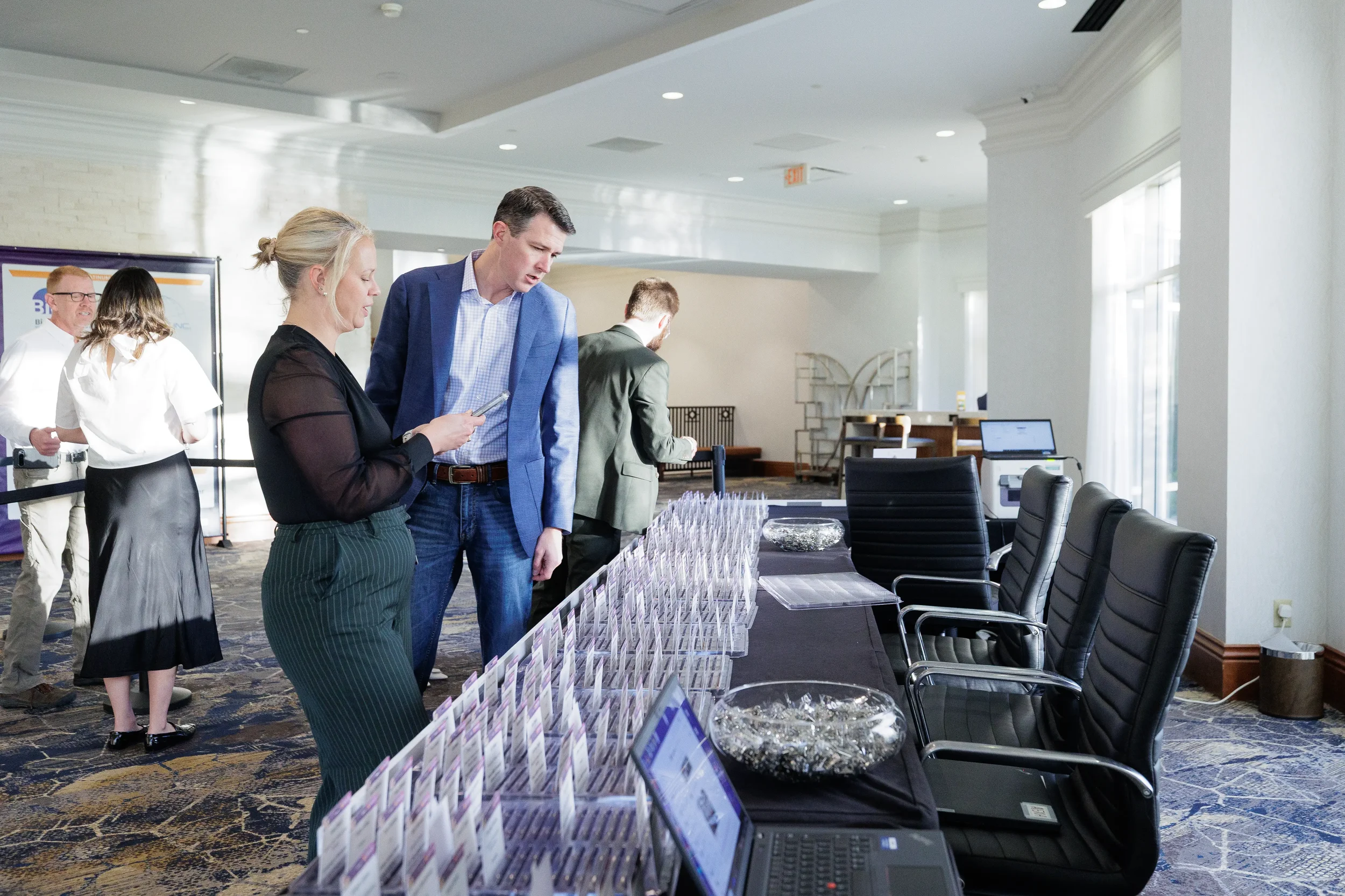 Attendees converse near registration table with name badges at Chicago corporate conference