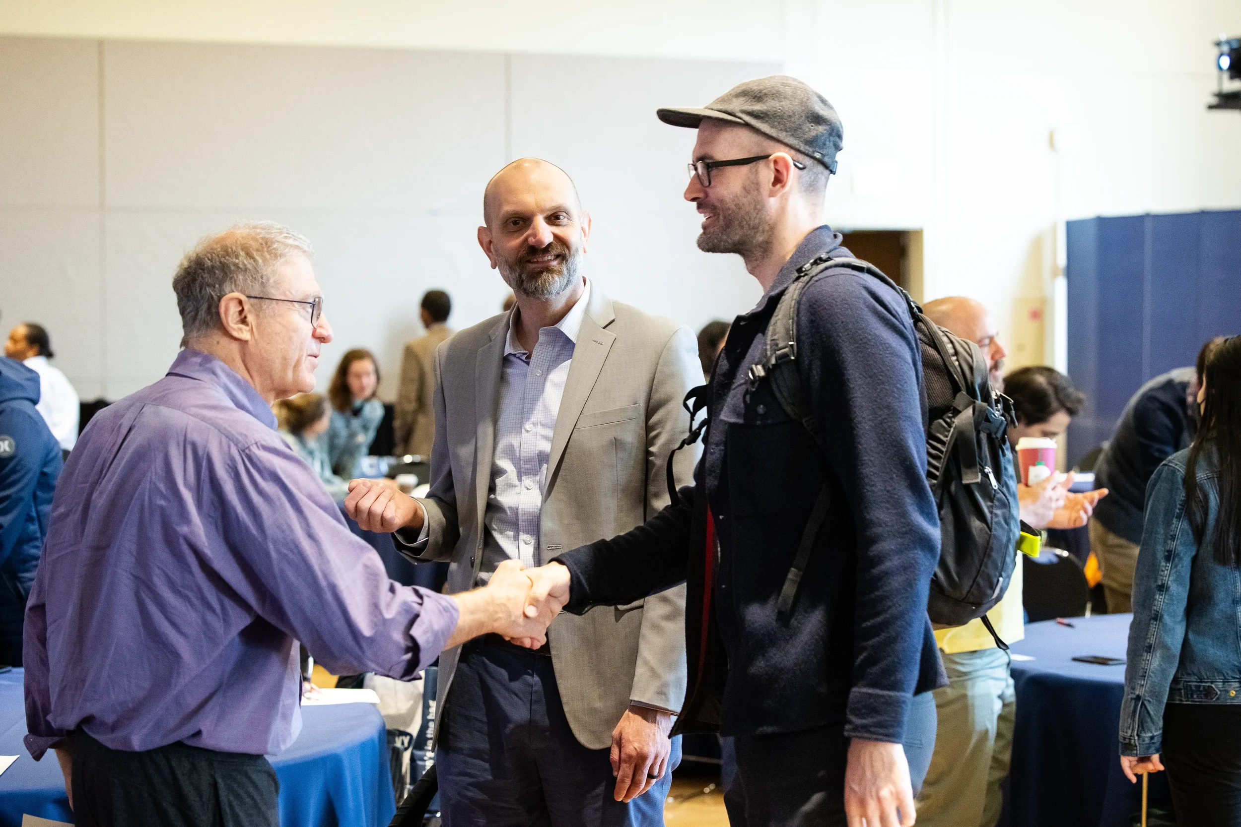 Attendees shake hands during networking at Chicago industry conference