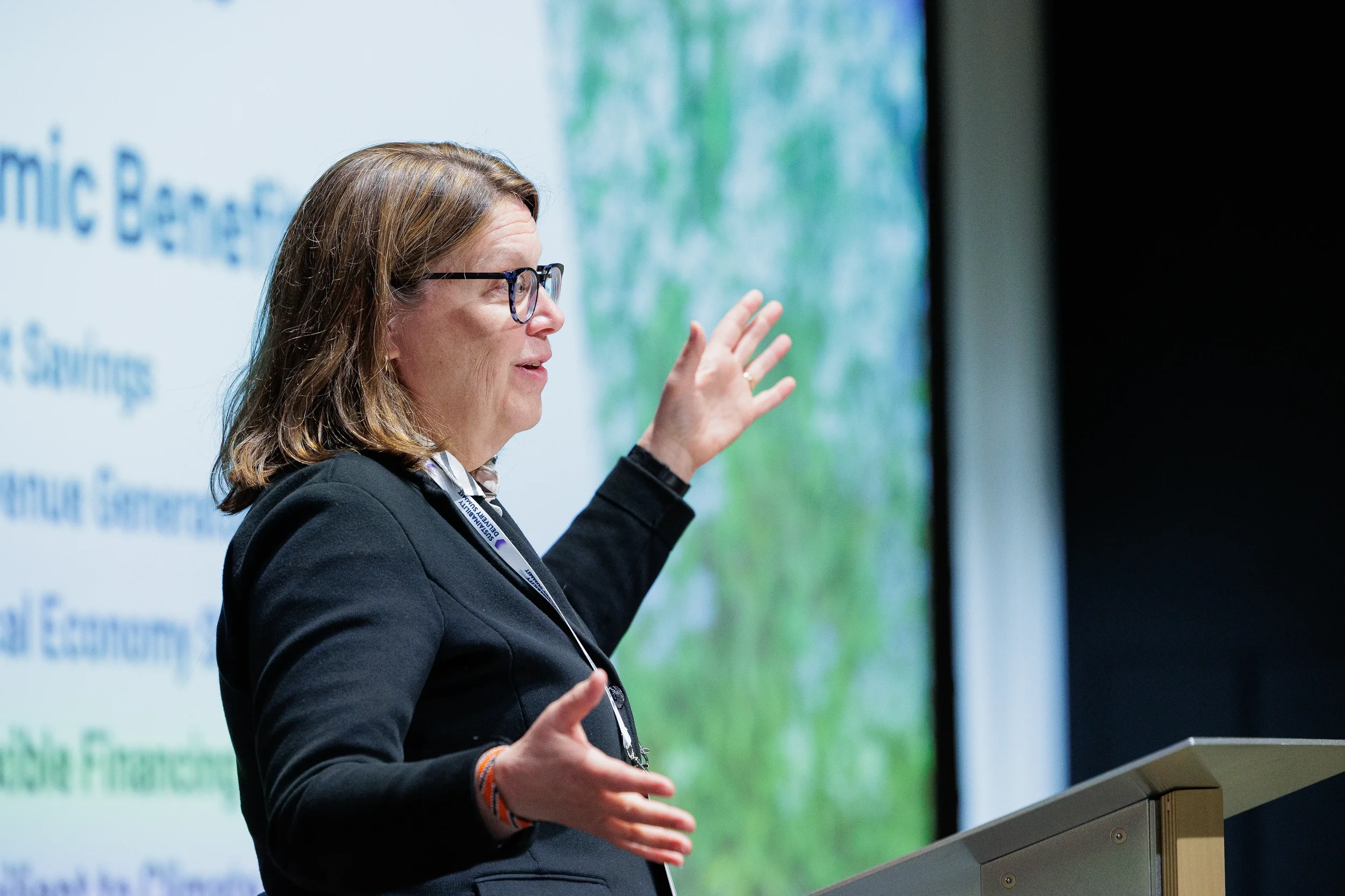 Speaker gestures while presenting from podium at Orlando industry conference session