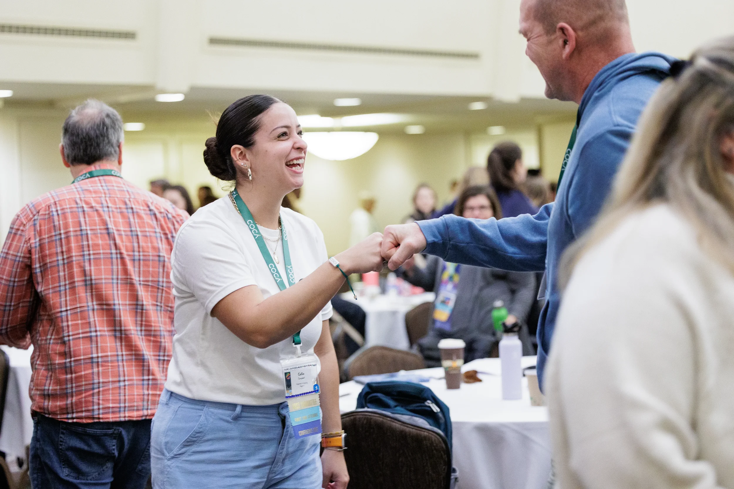 Two attendees share a fist bump and laugh together at Chicago nonprofit conference event