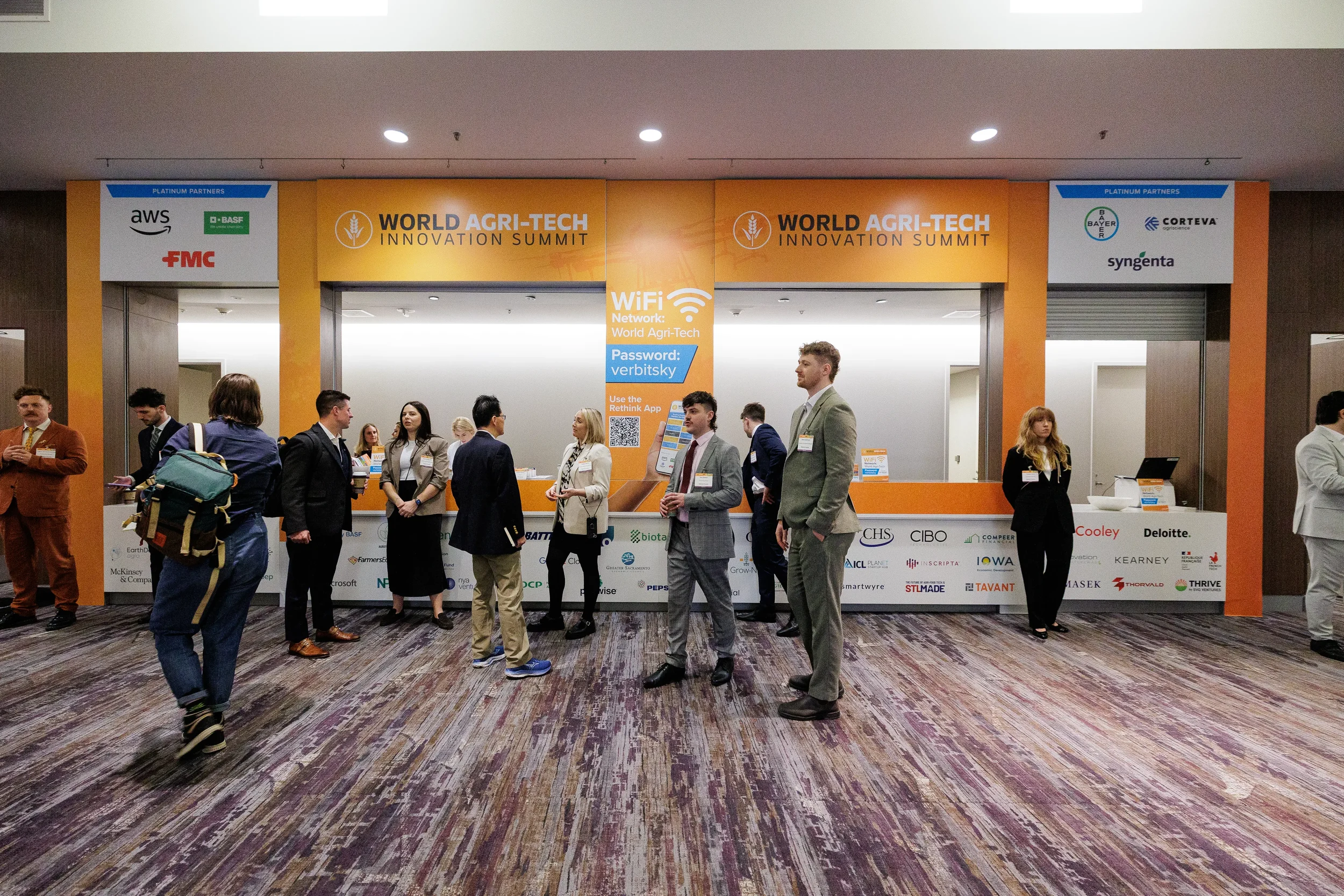 Attendees gather near branded registration desk with sponsor logos at Chicago corporate conference entrance
