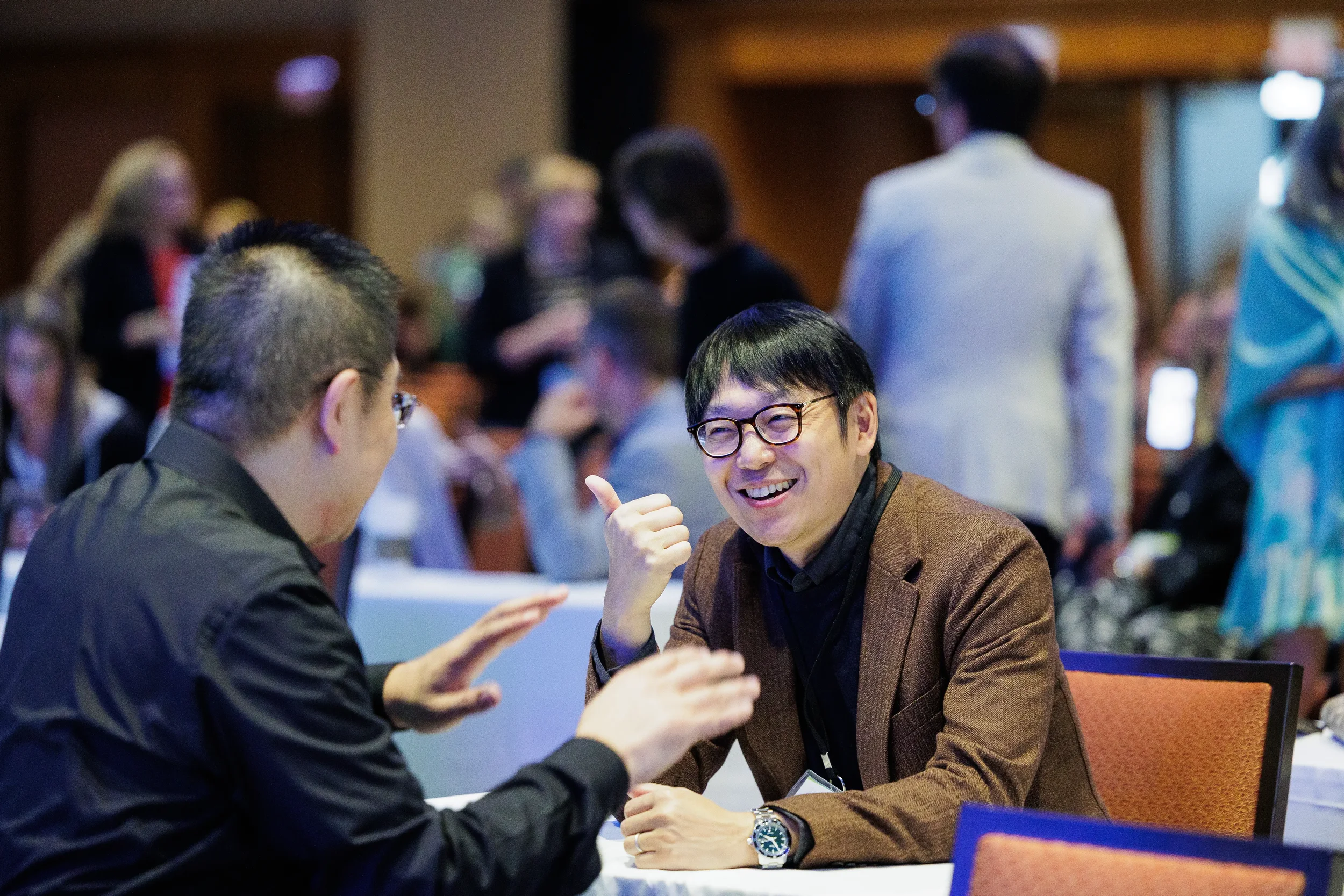 Attendees share a laugh with thumbs up gesture during seated conversation at Orlando conference