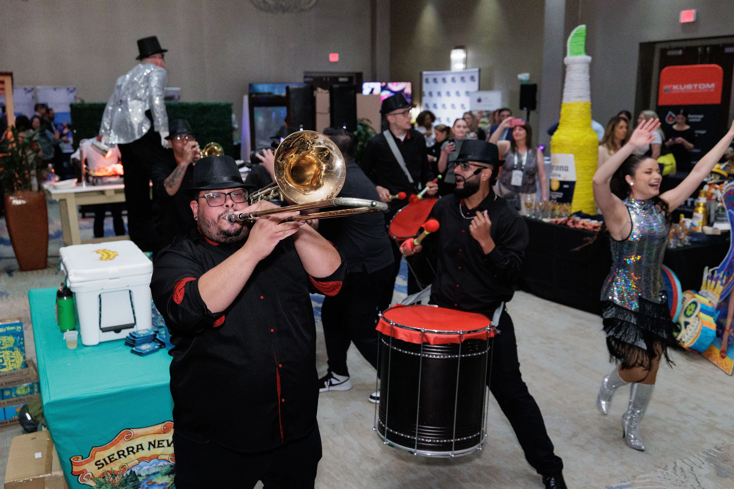 Live band performers play trombone and drum alongside dancer on Chicago corporate conference expo floor