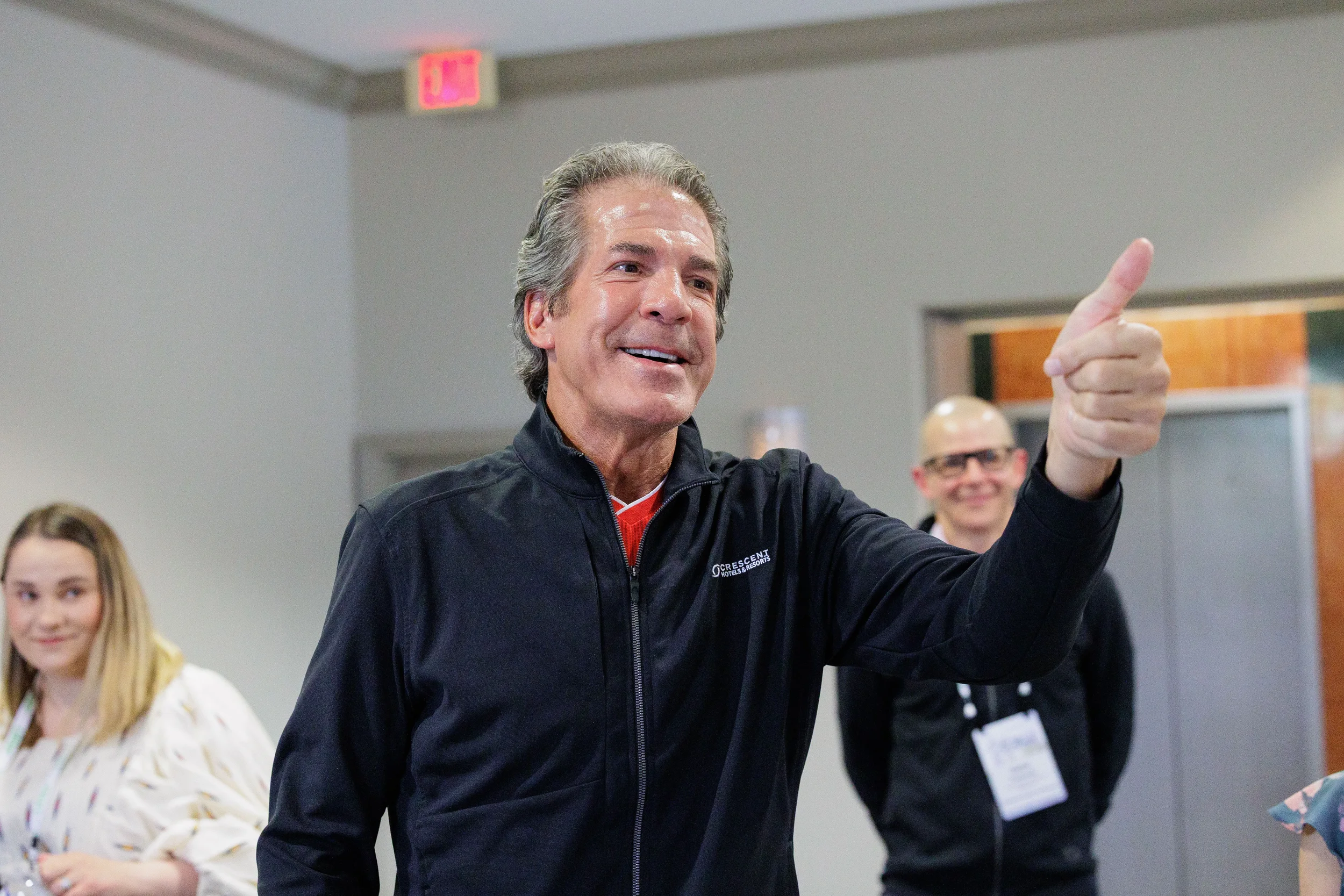 Smiling male attendee points enthusiastically during Orlando corporate conference session