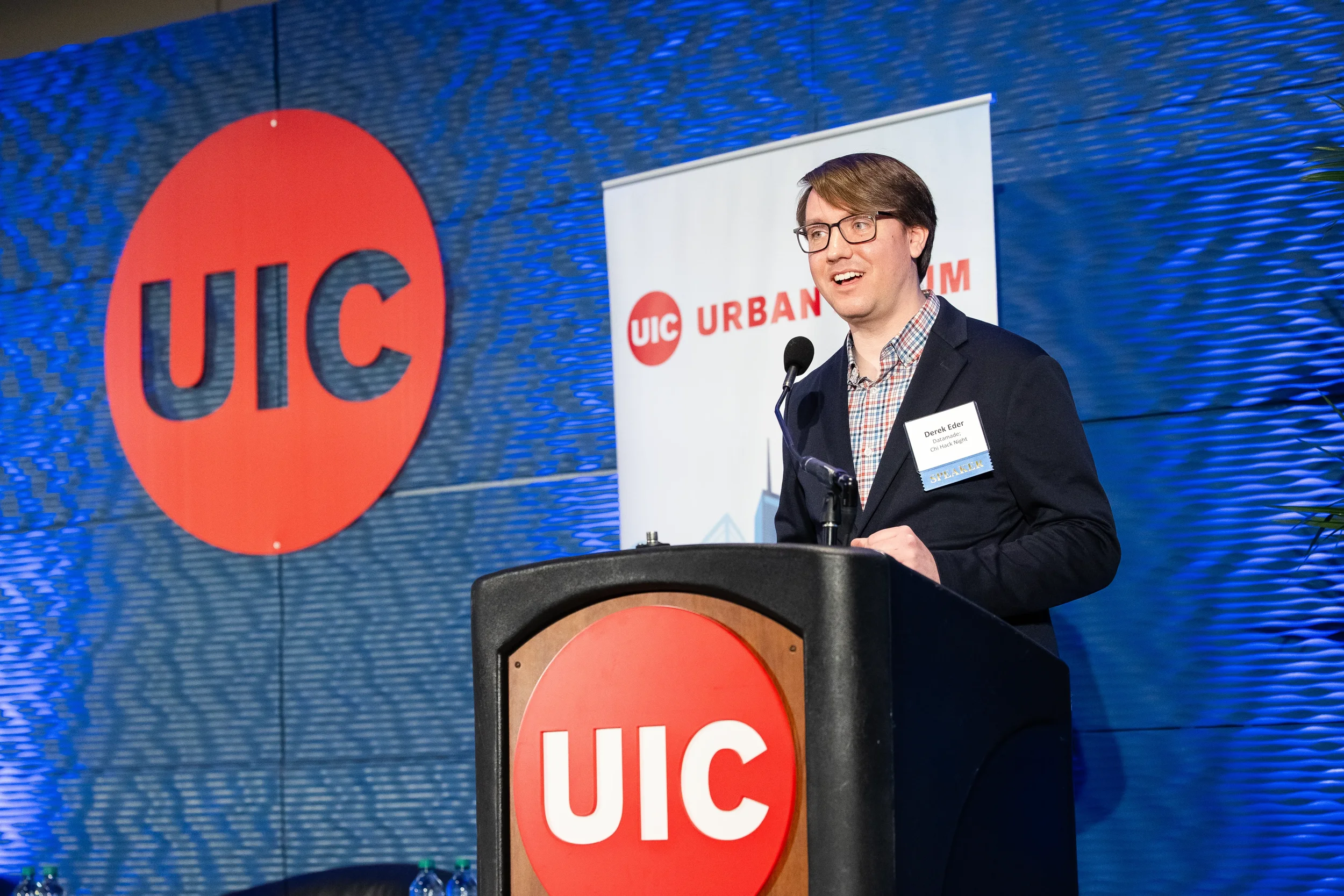 Speaker addresses audience from podium on branded stage at Chicago industry conference