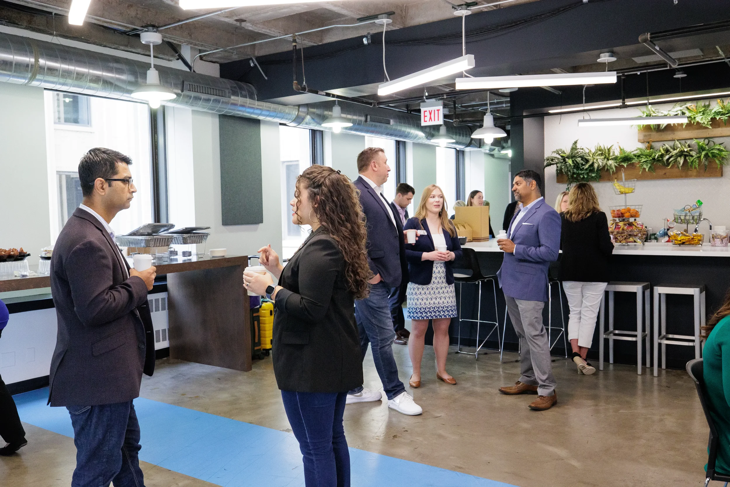 Attendees mingle with coffee cups near a bar area during a networking break at Chicago conference