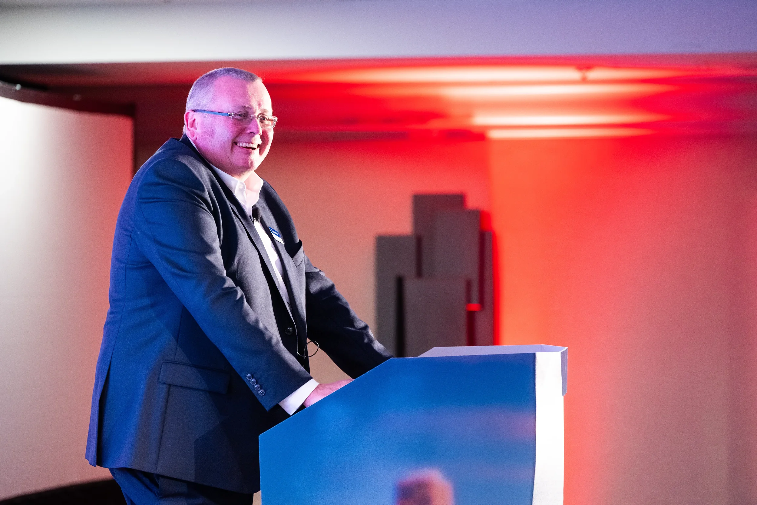 Keynote speaker smiles while presenting from podium at Orlando corporate event
