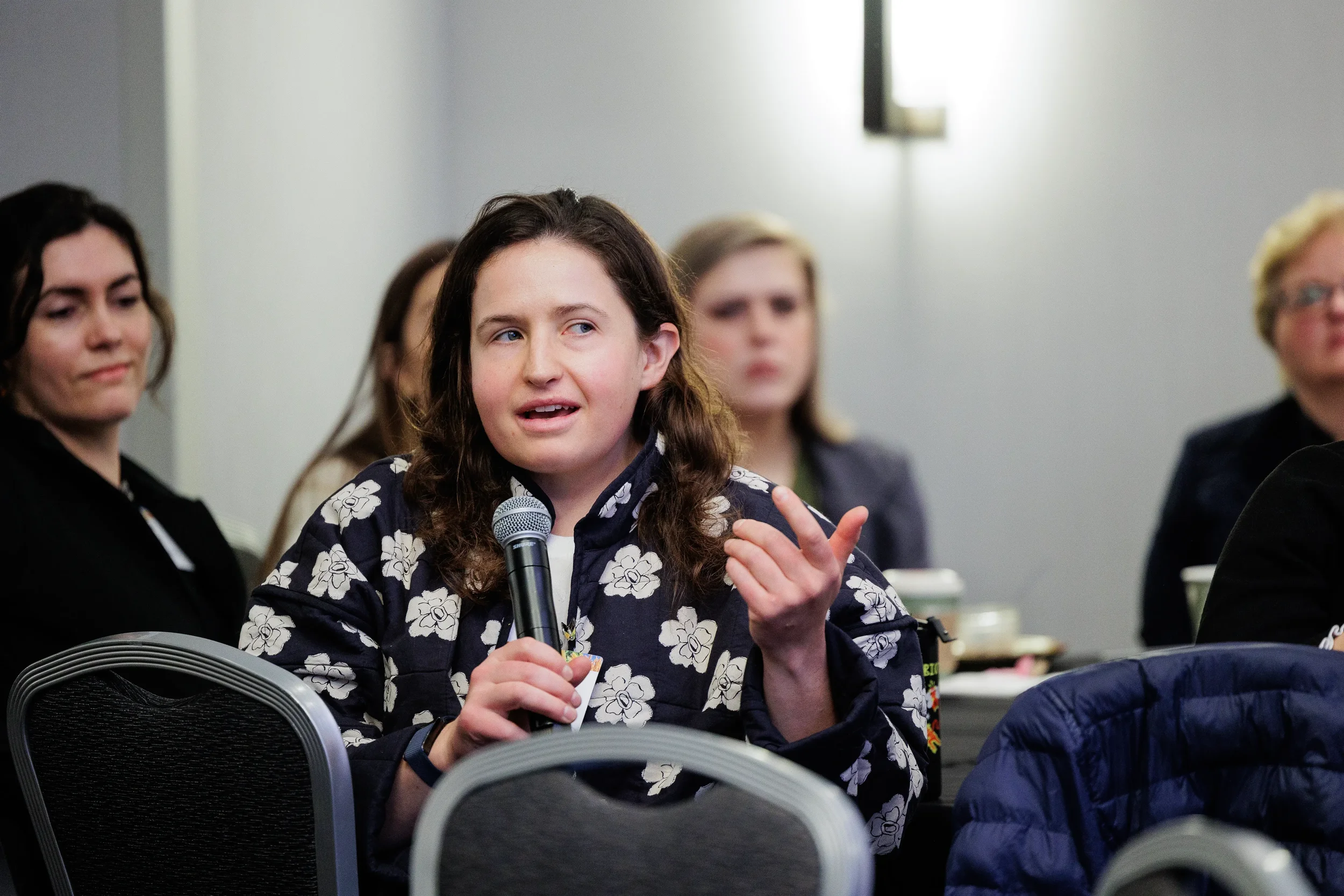 Attendee asks question into microphone from seated audience at Chicago industry conference