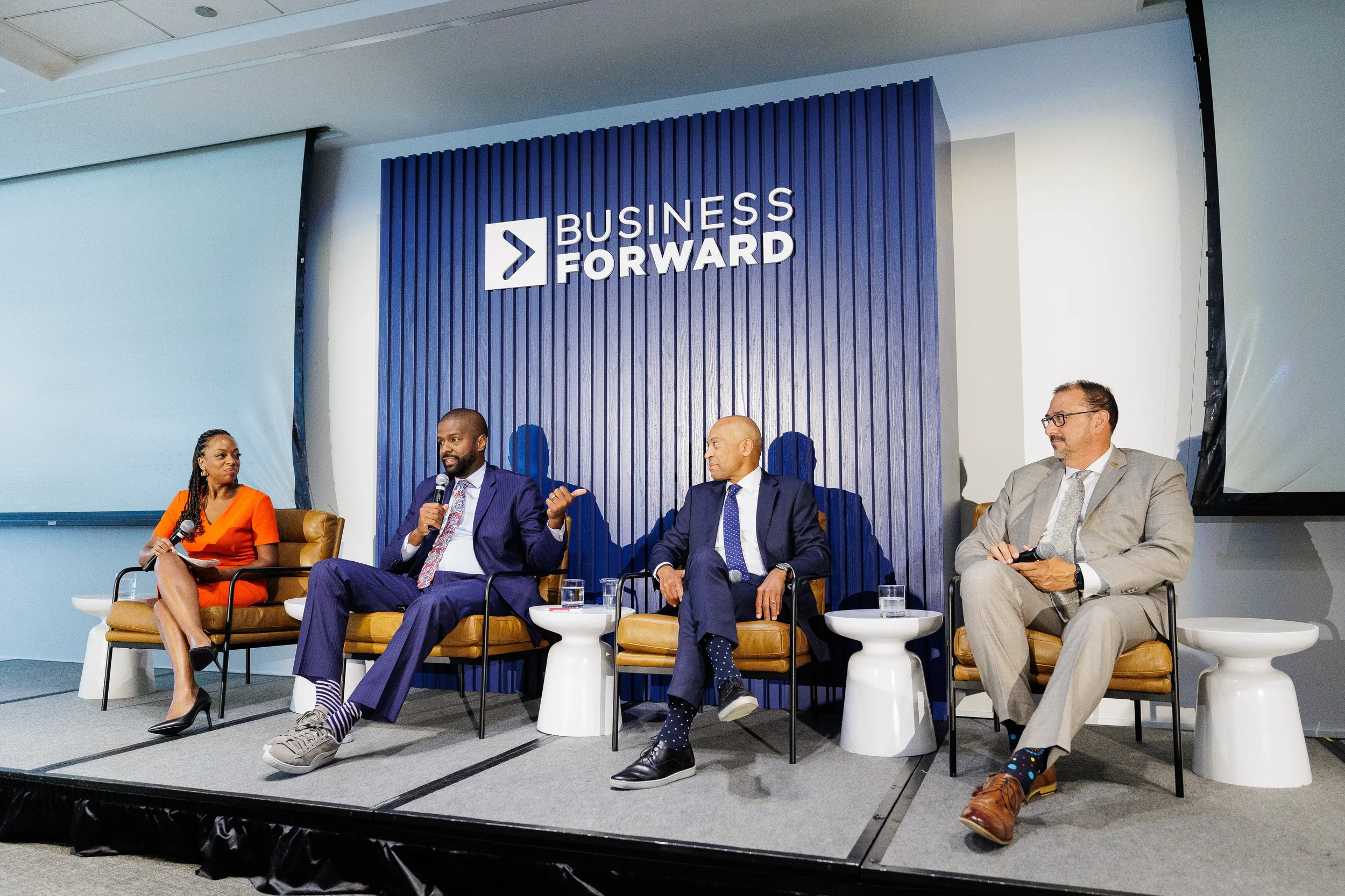 Four panelists engage in discussion on stage at Chicago corporate conference event