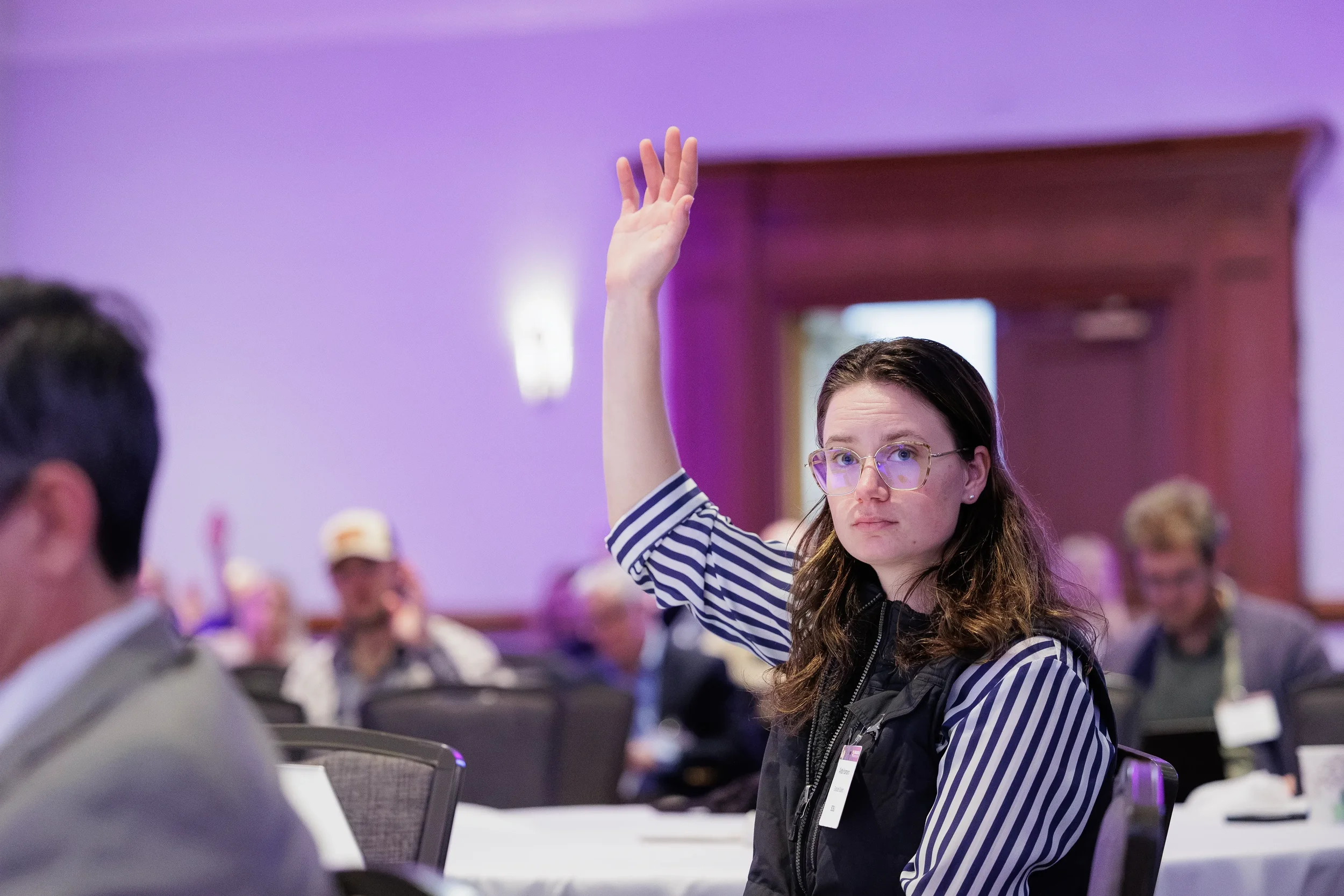 Attendee raises hand to ask question during session at Chicago industry conference