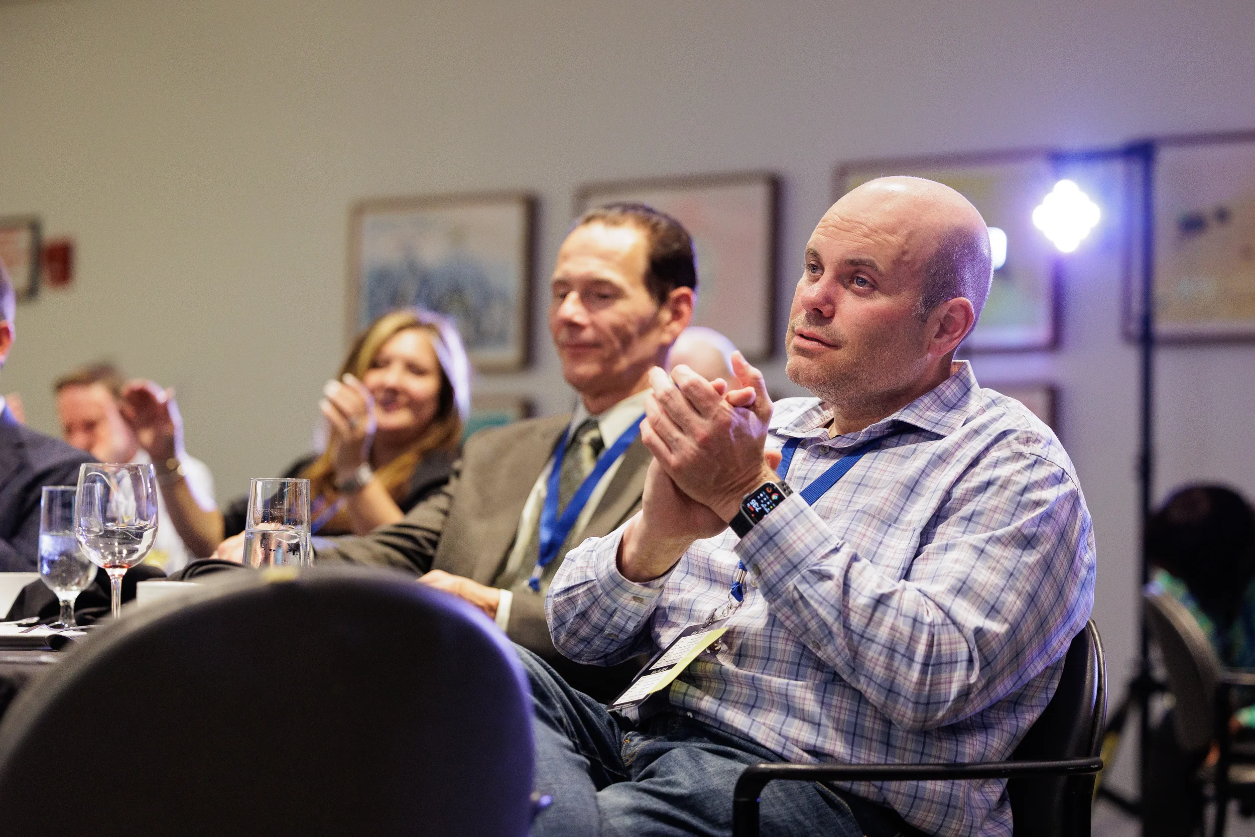 Attendees with lanyards applaud while seated at Orlando corporate conference evening event