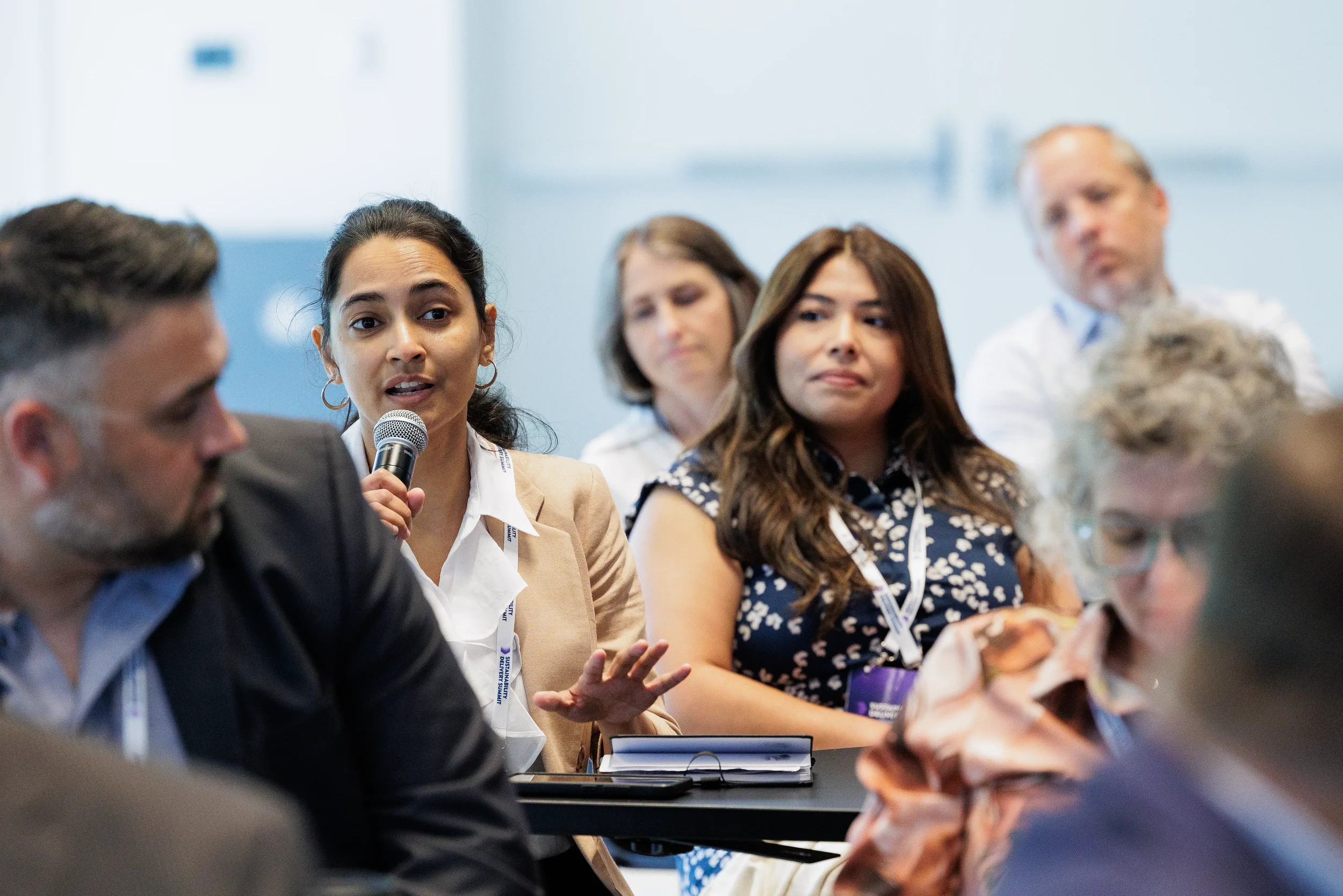 Audience member asks question with microphone during panel session at Orlando corporate conference