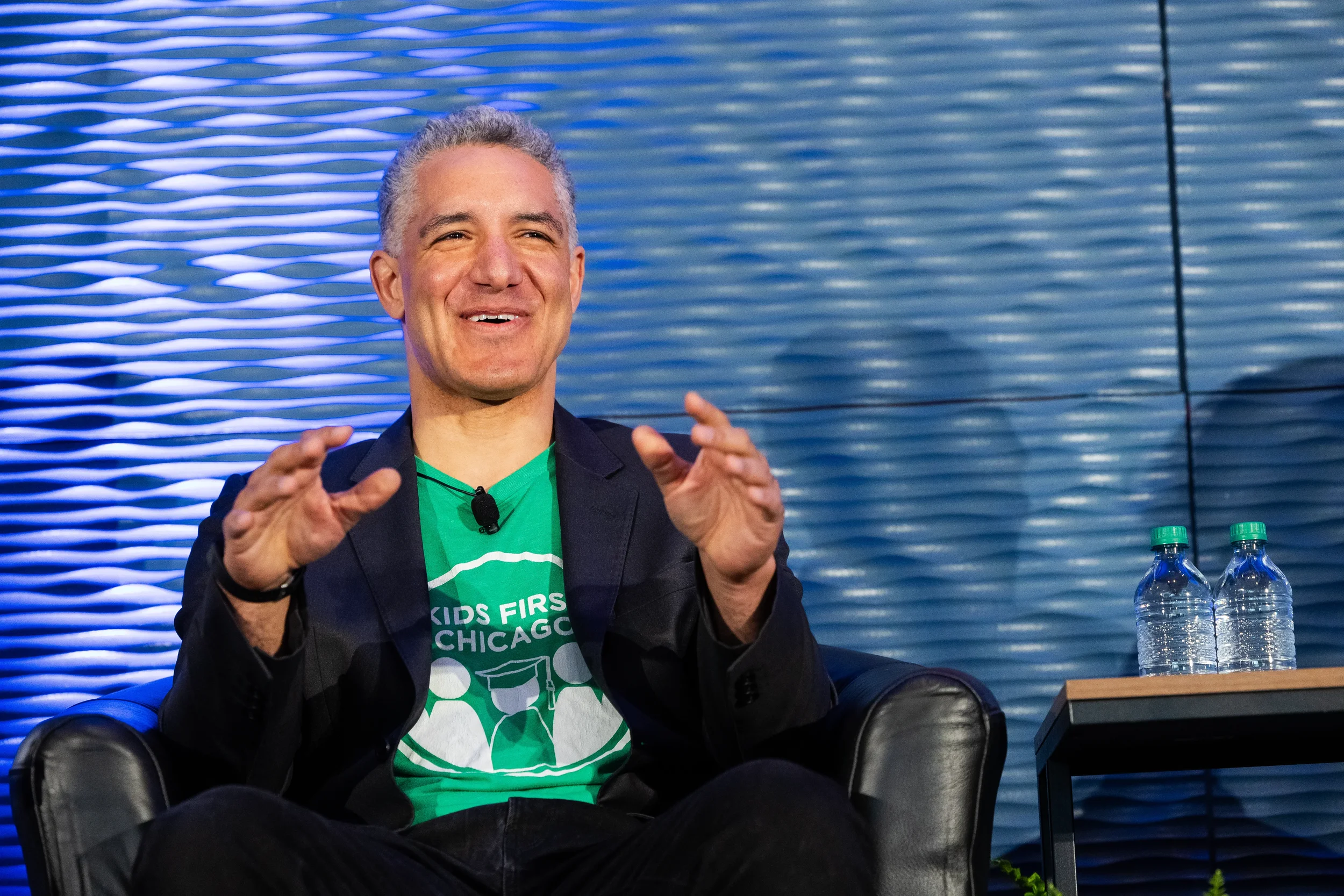 Panelist laughs while gesturing during stage discussion at Chicago corporate conference