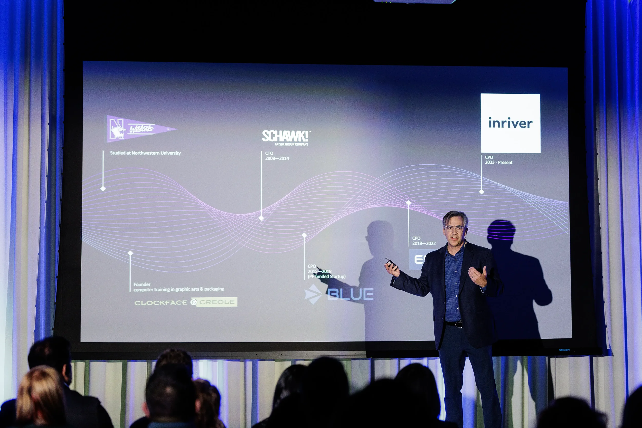 Speaker gestures beside career timeline slide on stage before audience at Orlando corporate conference
