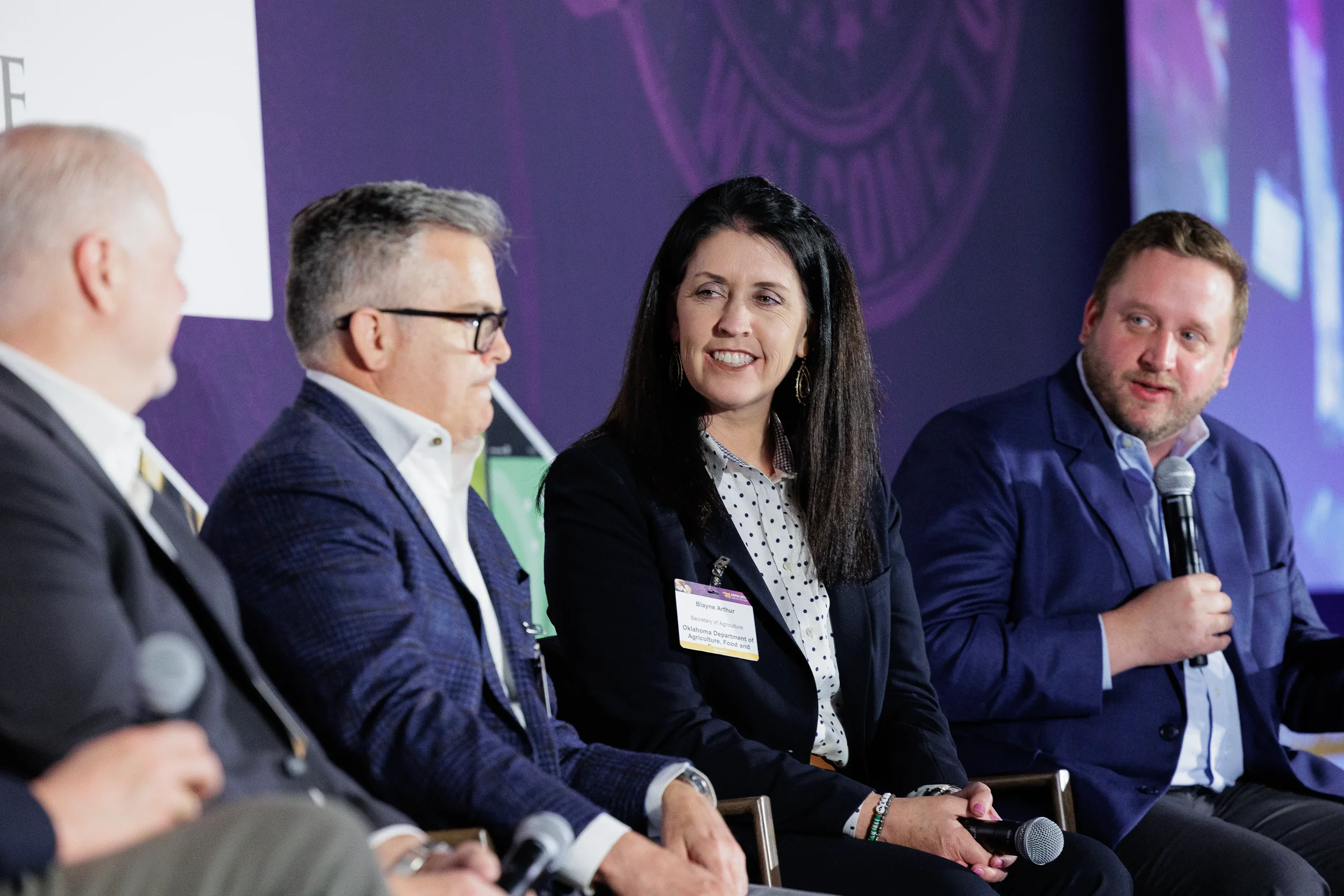 Panelist speaks into microphone during seated discussion at Orlando industry summit