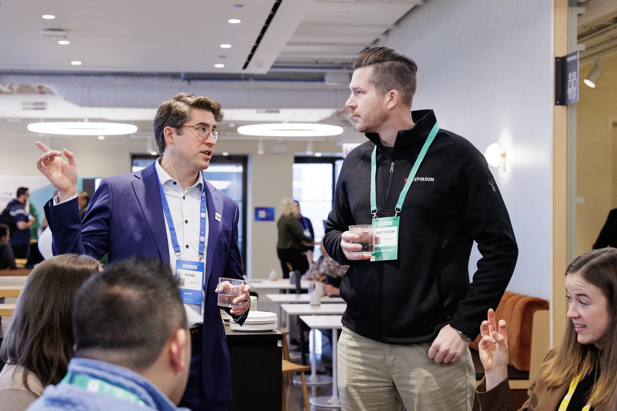 Two attendees chat while holding drinks in networking lounge at Chicago corporate conference reception