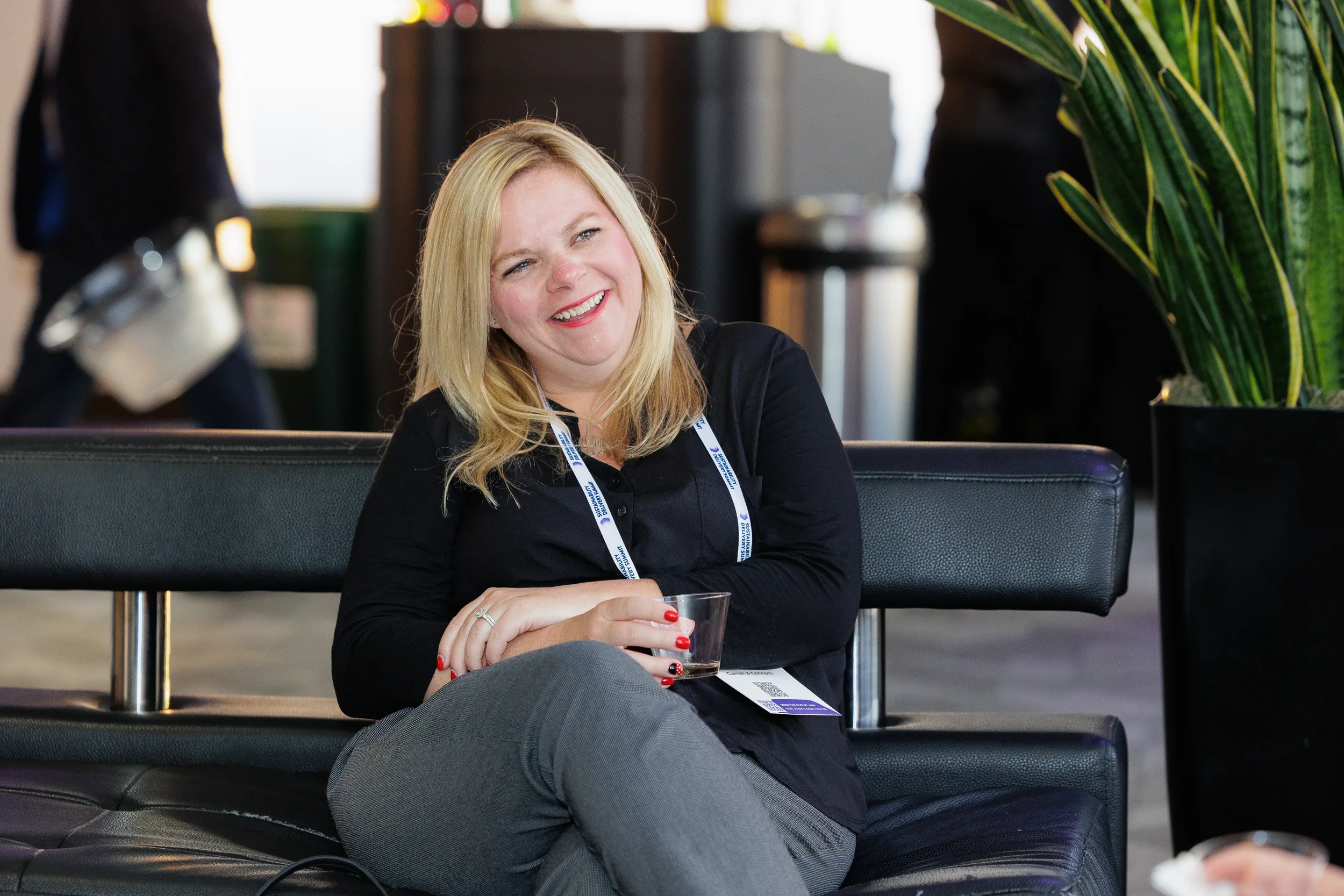 Attendee smiles while seated in lounge area during Chicago corporate conference break
