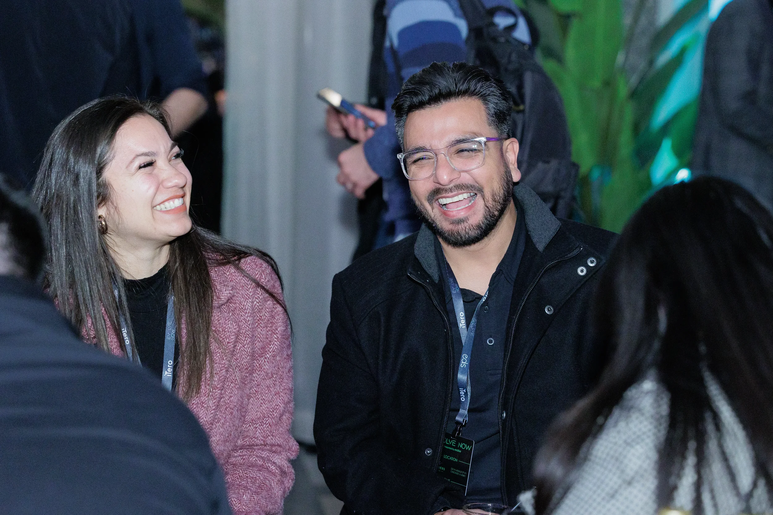 Two attendees laugh together wearing lanyards at Chicago corporate event evening reception