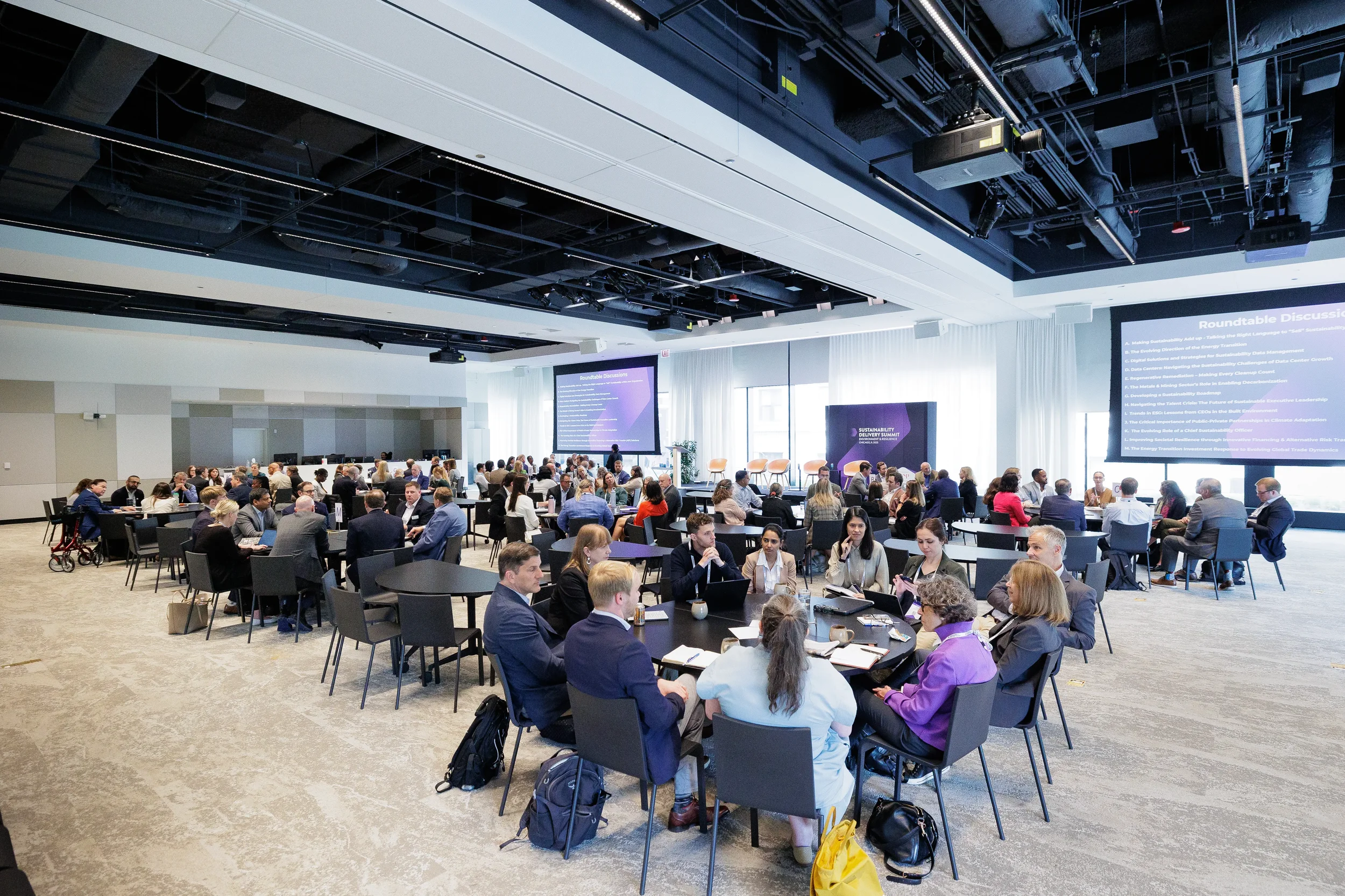 Wide view of roundtable discussions with attendees seated at Chicago industry conference session