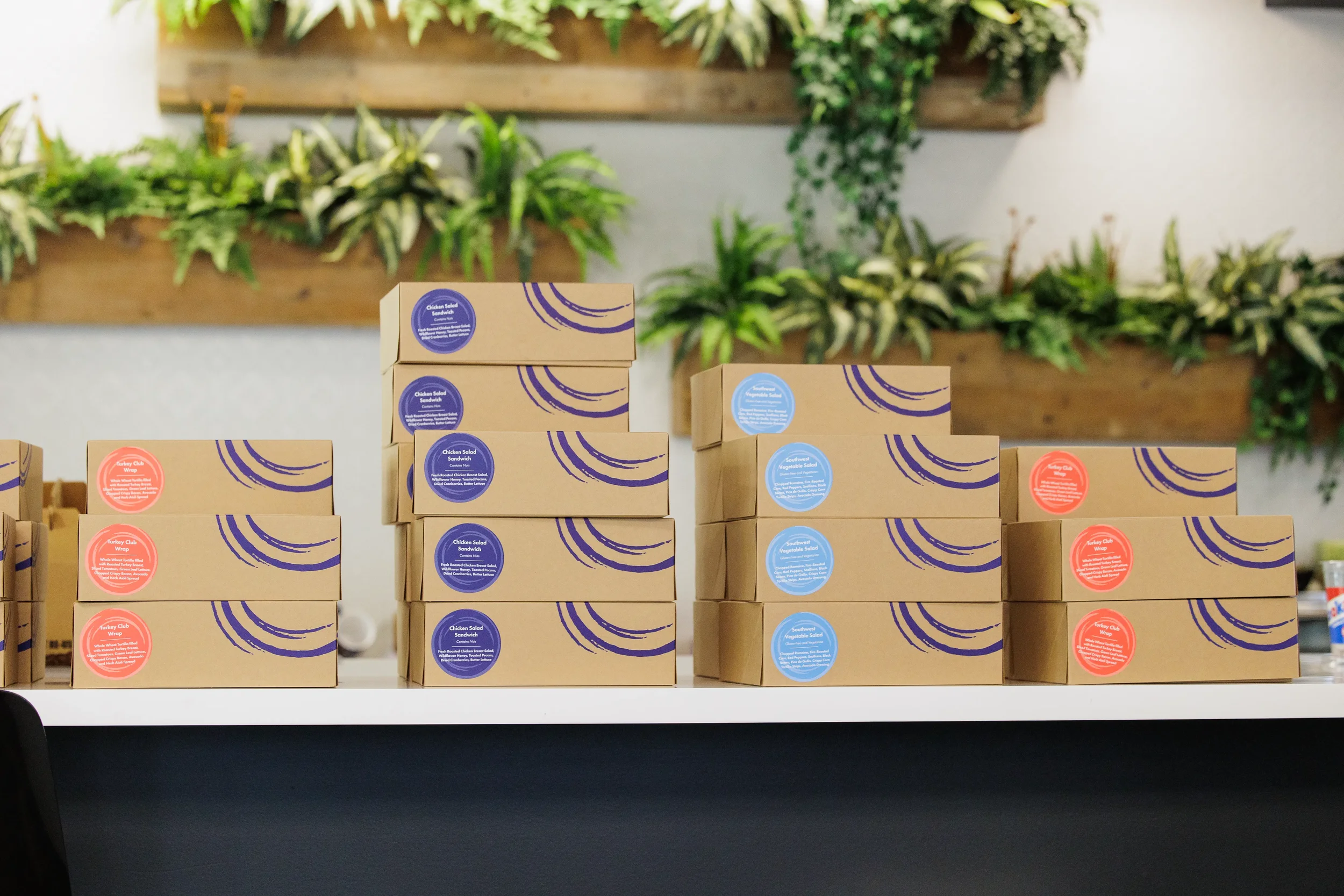 Stacked labeled boxed lunches arranged on a table at an Orlando corporate event venue