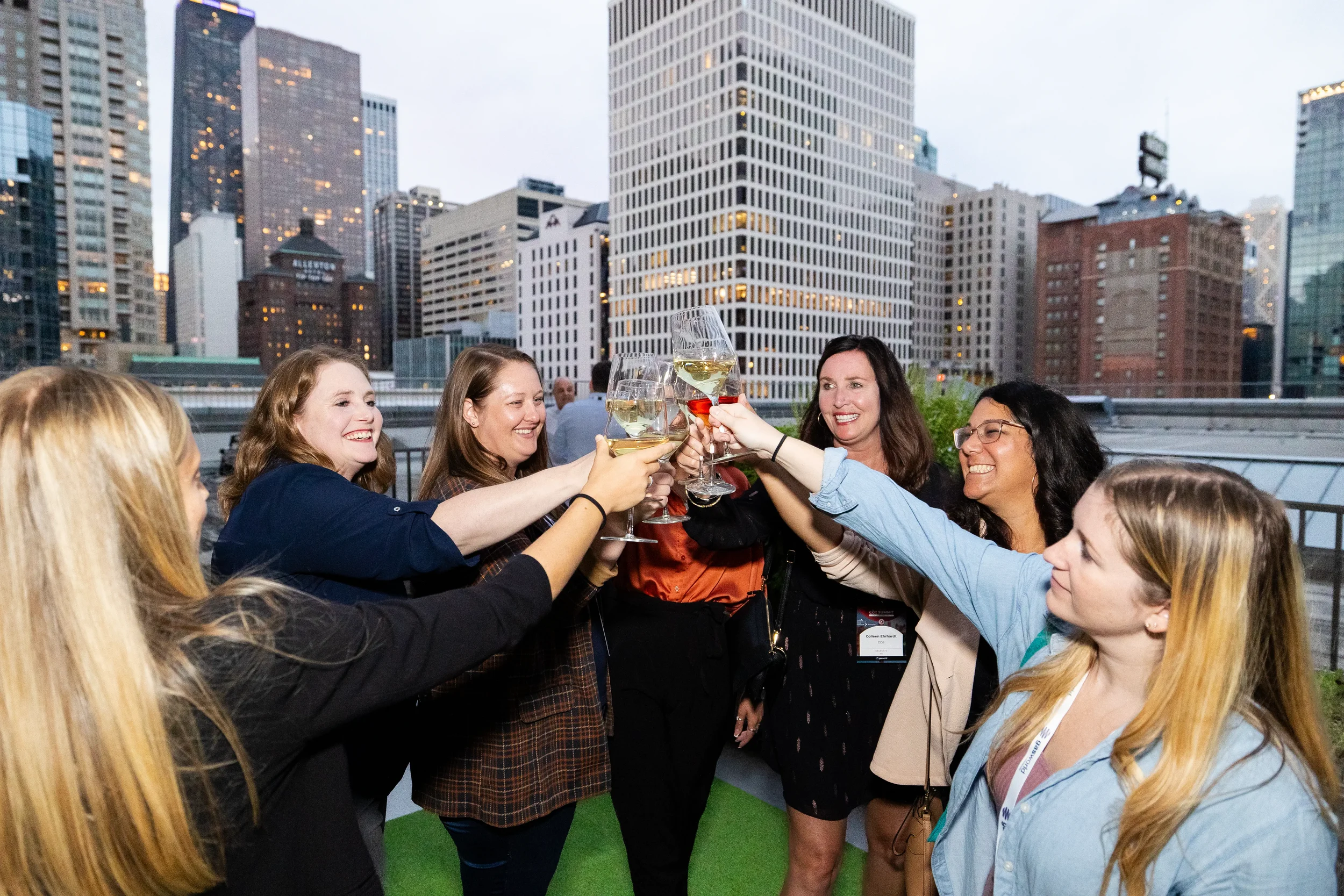 Conference attendees raise glasses for a toast at rooftop networking reception in Orlando