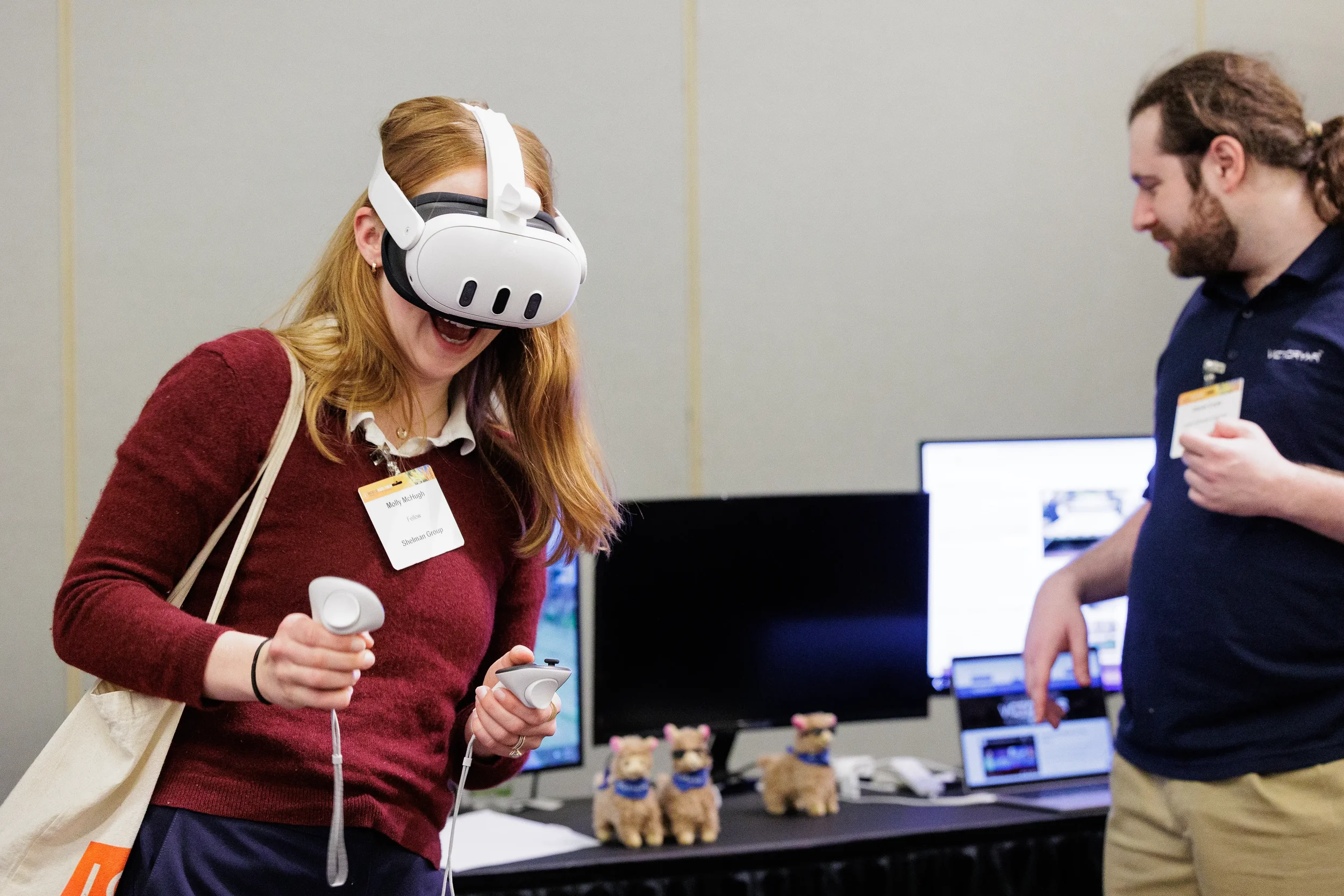 Attendee with name badge laughs while trying VR headset at trade show booth at Orlando industry conference