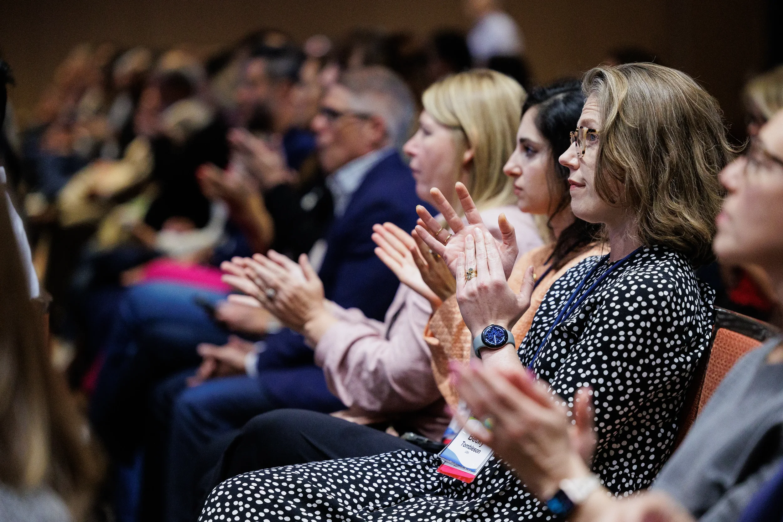 Seated attendees applaud during session at Chicago corporate conference