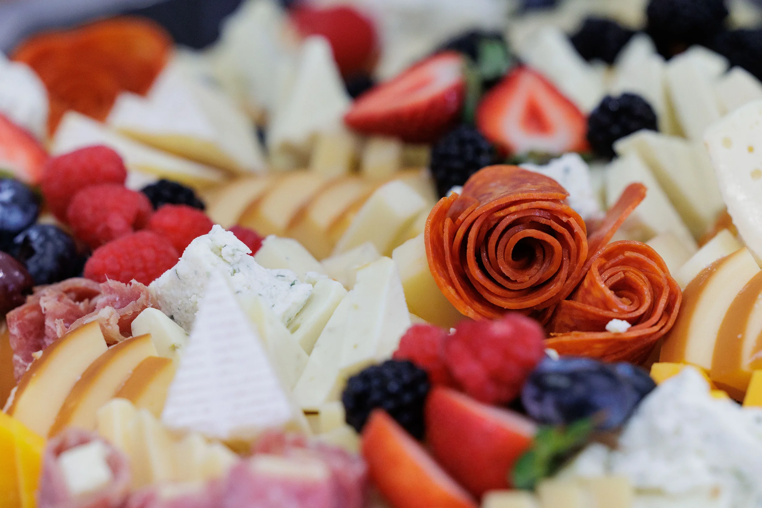 Close-up of elaborate charcuterie board with cheese, fruit, and salami roses at Orlando corporate event