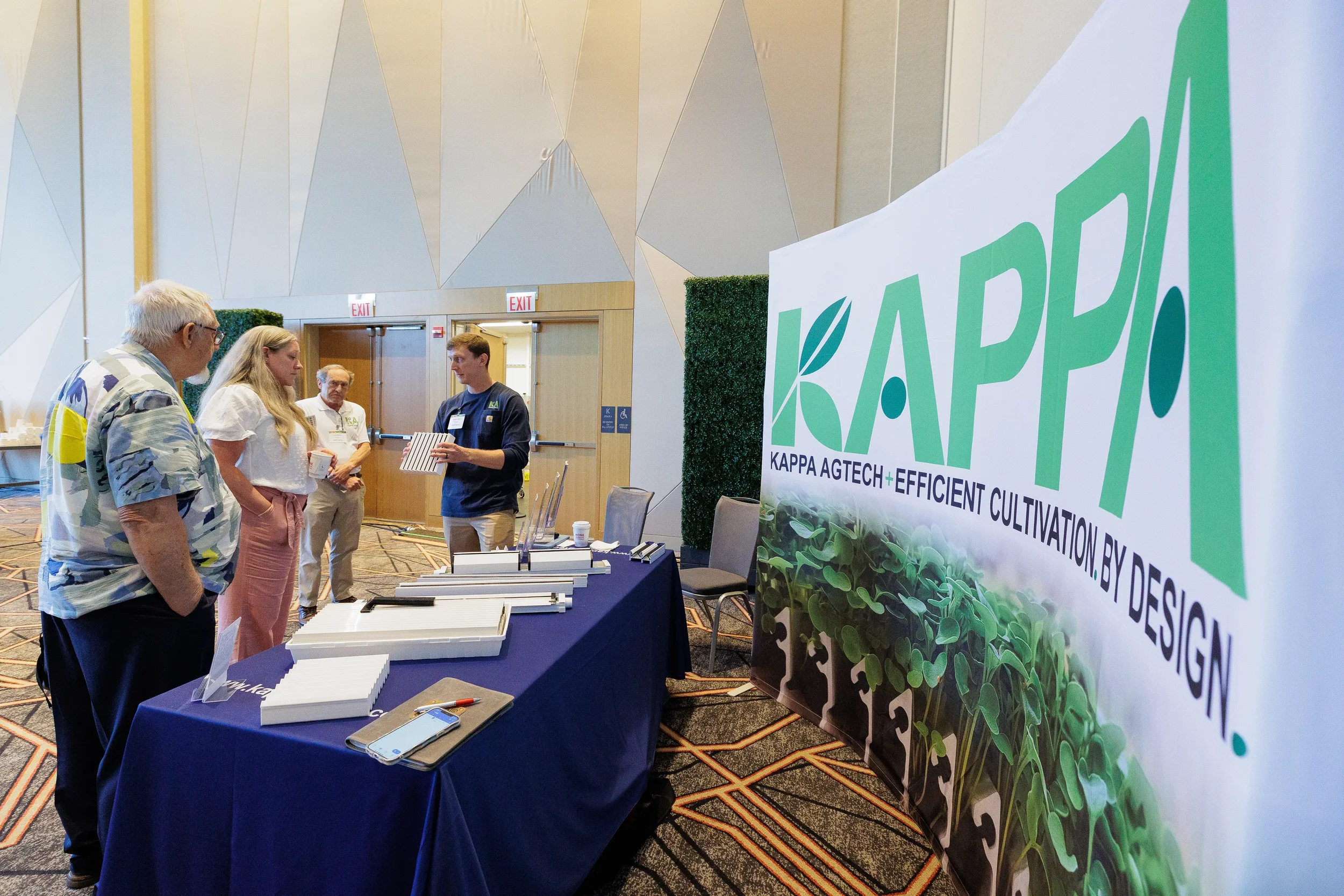 Exhibitor demonstrates product to attendees at trade show booth during Orlando conference
