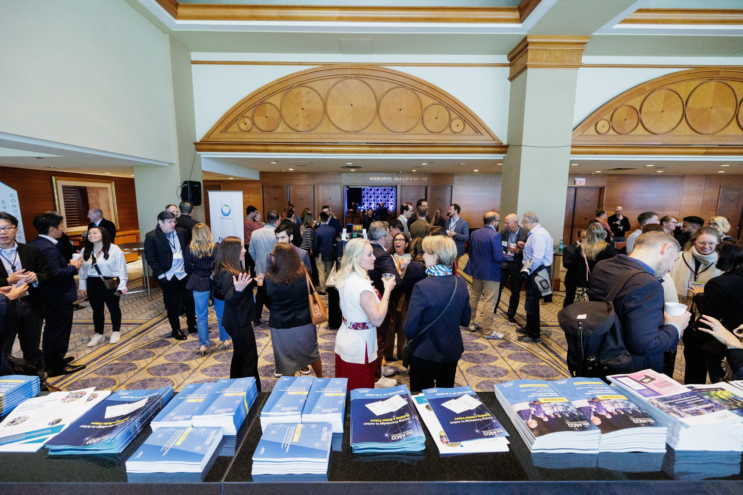 Attendees network and converse in lobby reception area at Chicago industry conference