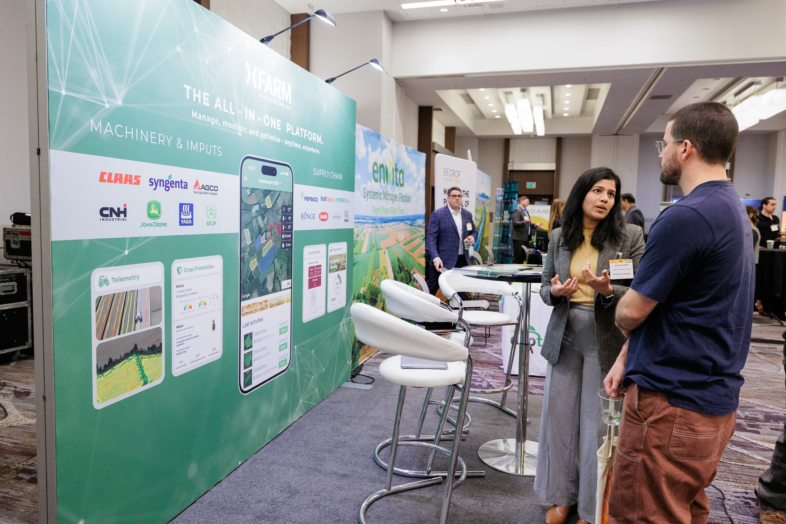 Attendees discuss agricultural technology platform at exhibitor booth on Chicago expo floor