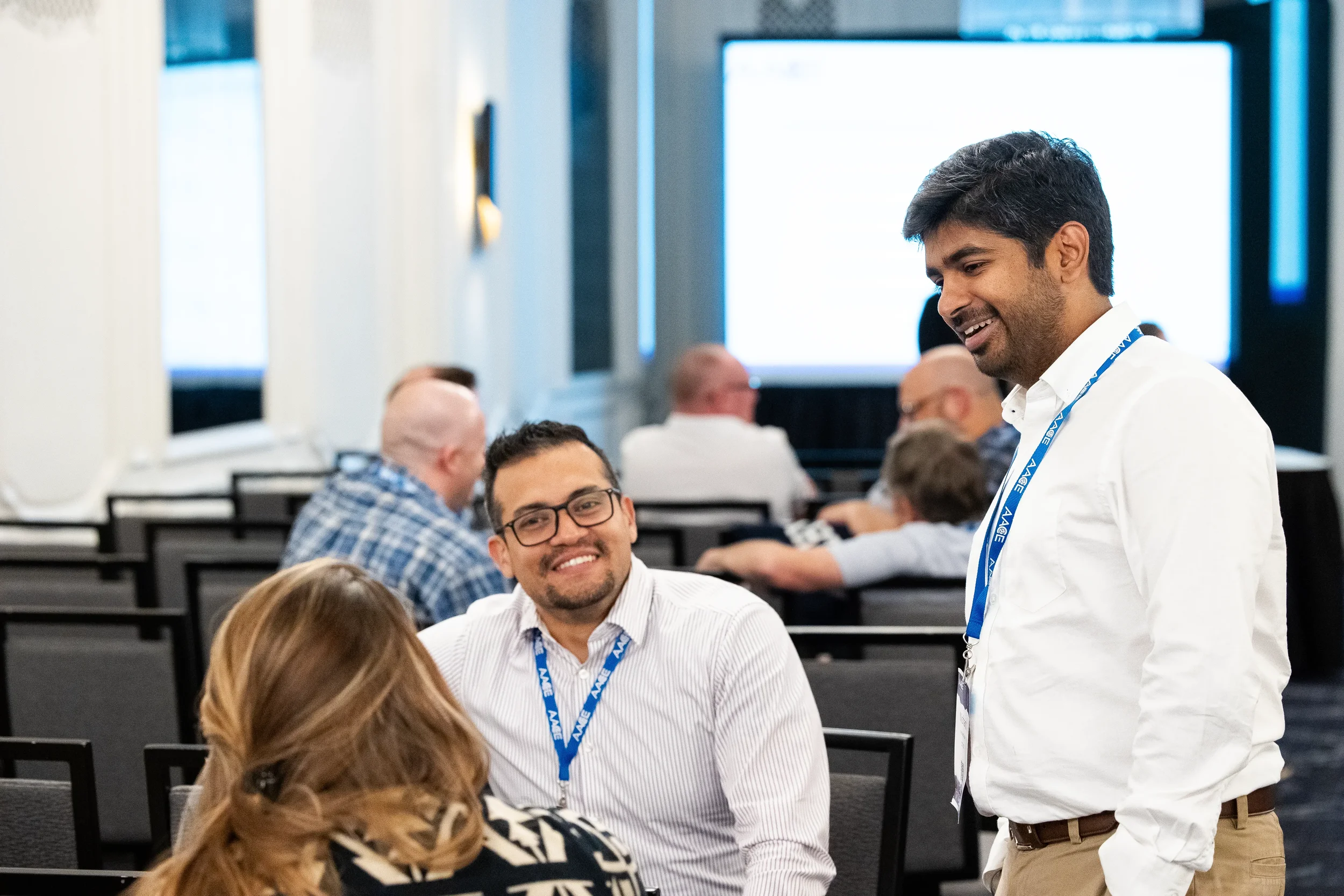 Attendees smile while networking between sessions at Orlando conference breakout room