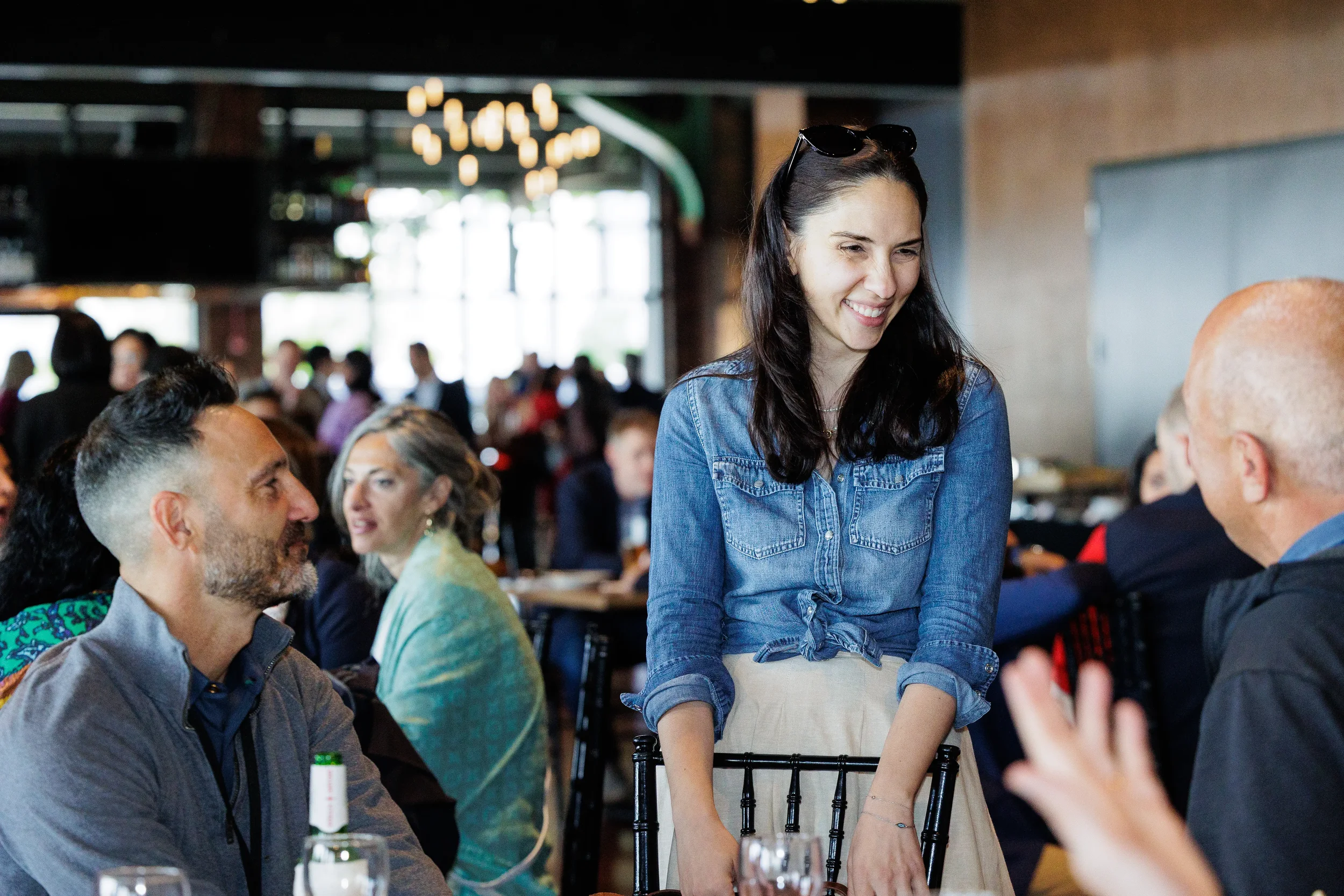 Attendee smiles during conversation at seated table during Orlando networking event