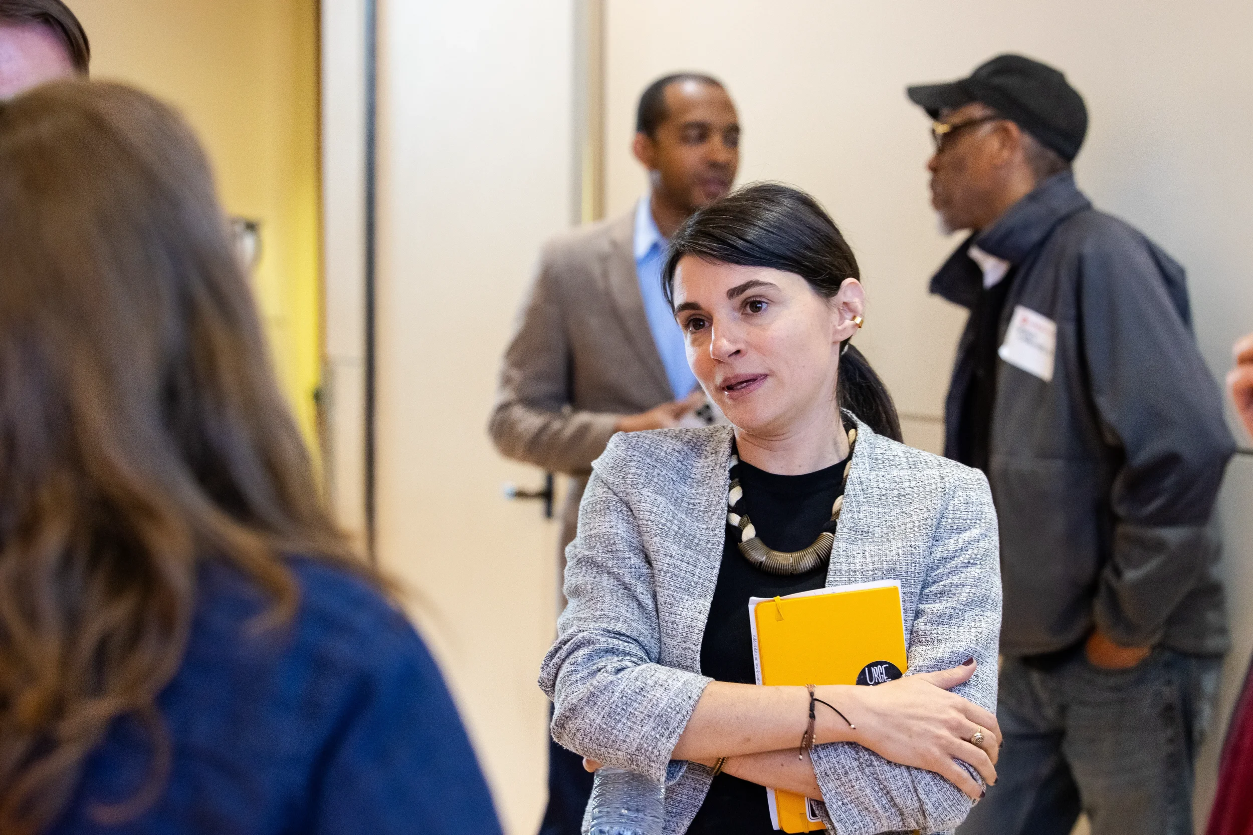 Attendee holds notebook while conversing during networking break at Chicago corporate conference