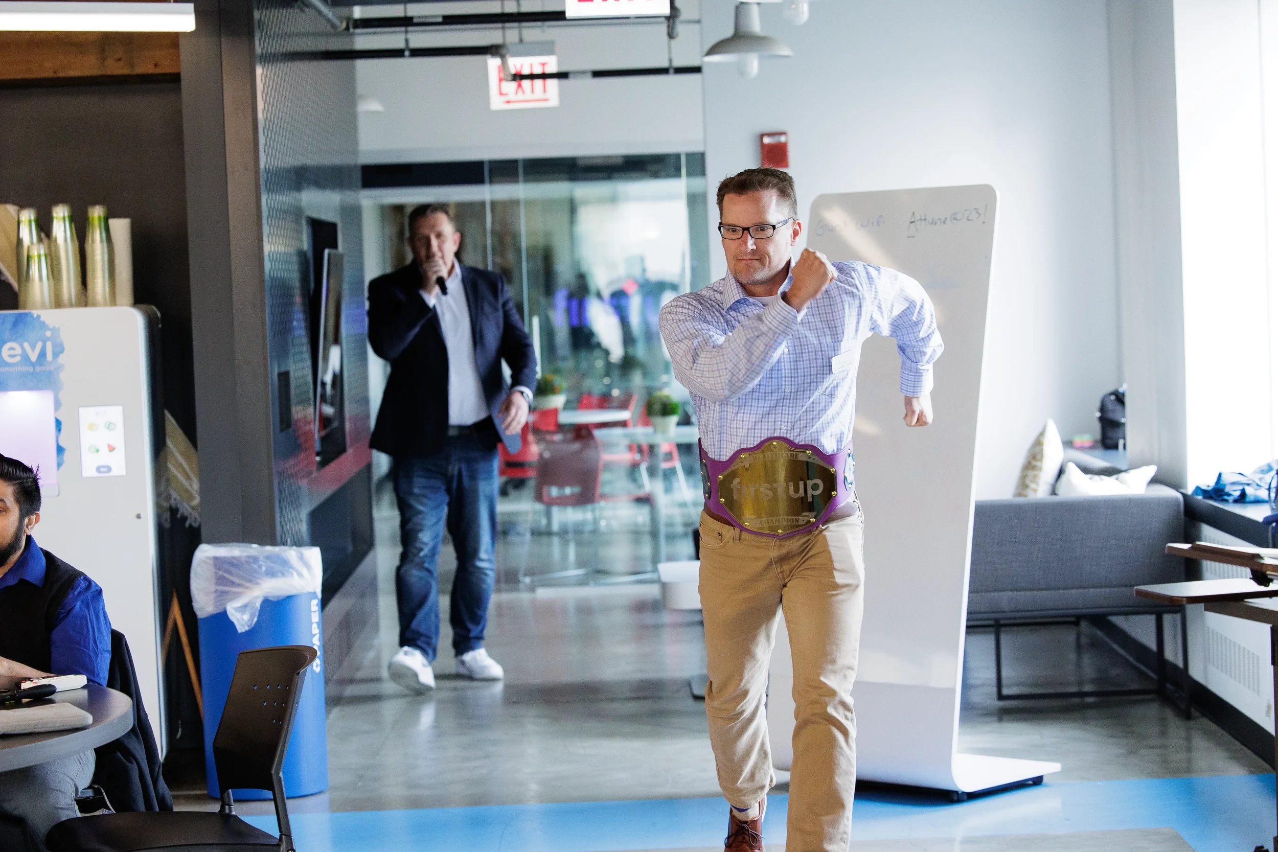 Attendee wearing branded champion belt celebrates energetically in event space at Orlando conference