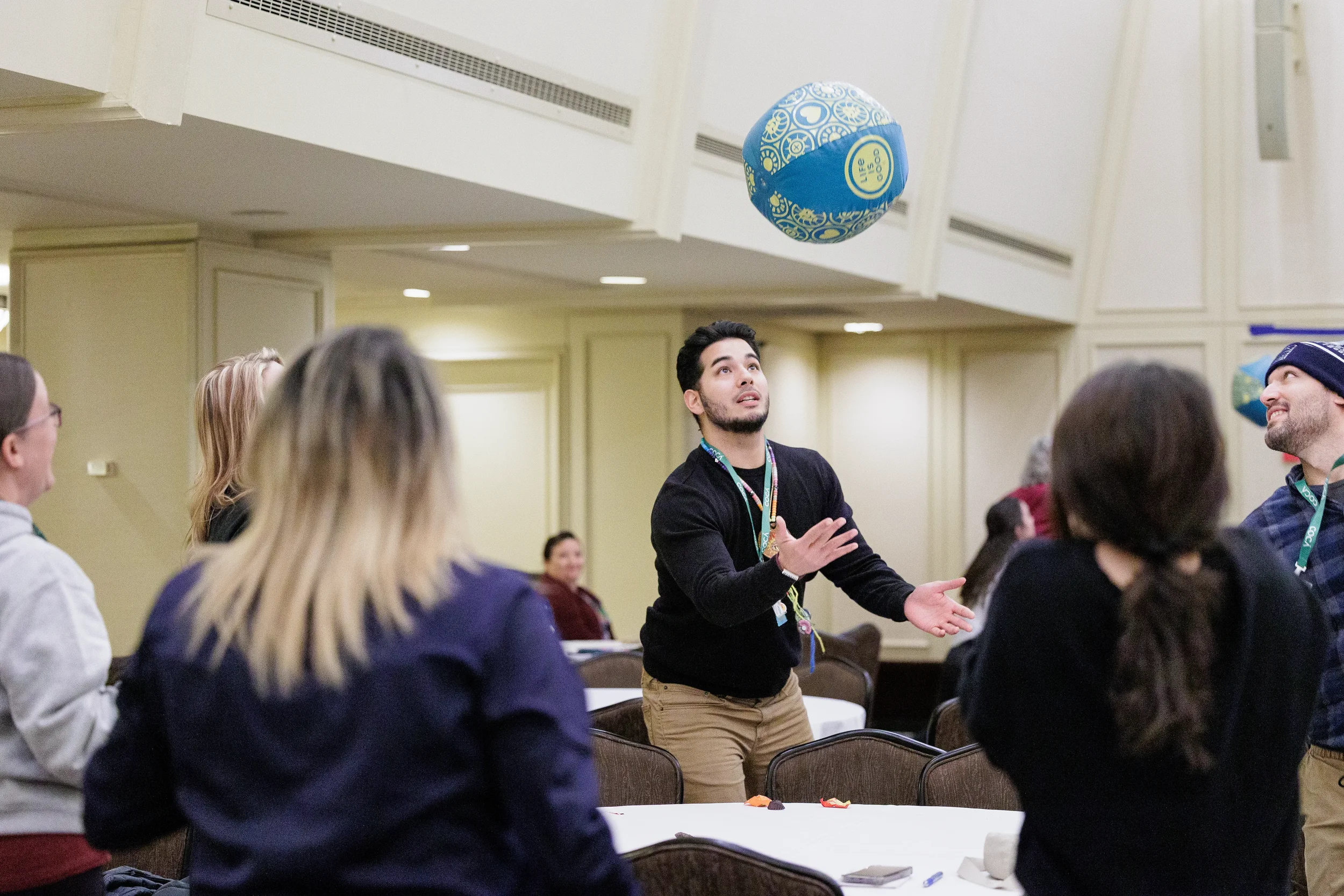 Attendee tosses a ball during interactive group activity at Chicago nonprofit conference event