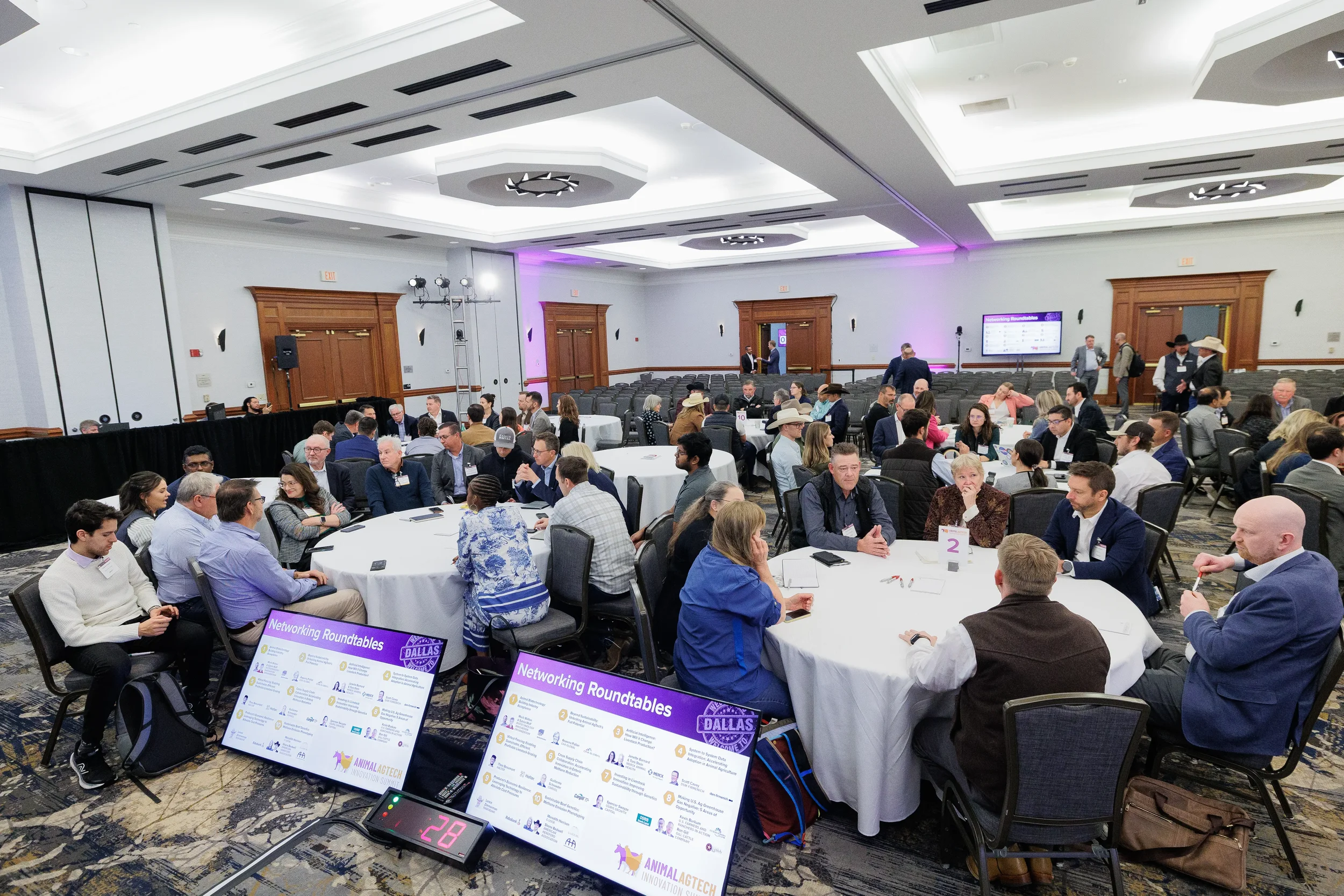 Wide view of attendees at networking roundtables during Orlando industry conference