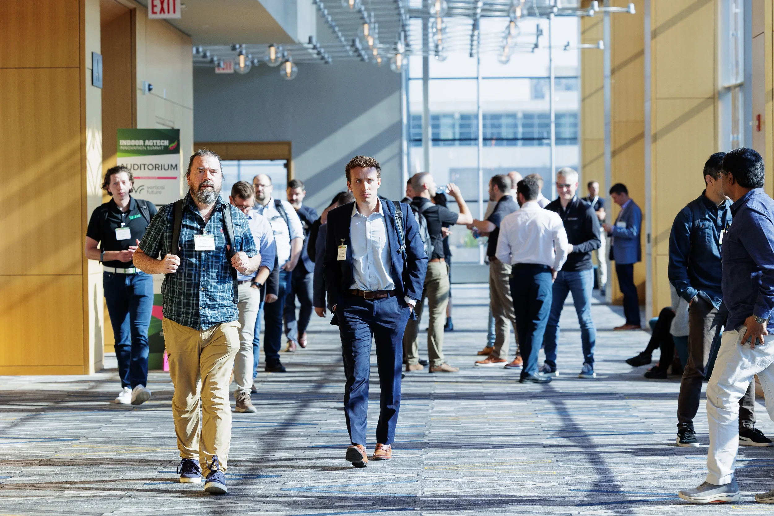 Attendees walk through sunlit convention center hallway between sessions at Orlando conference