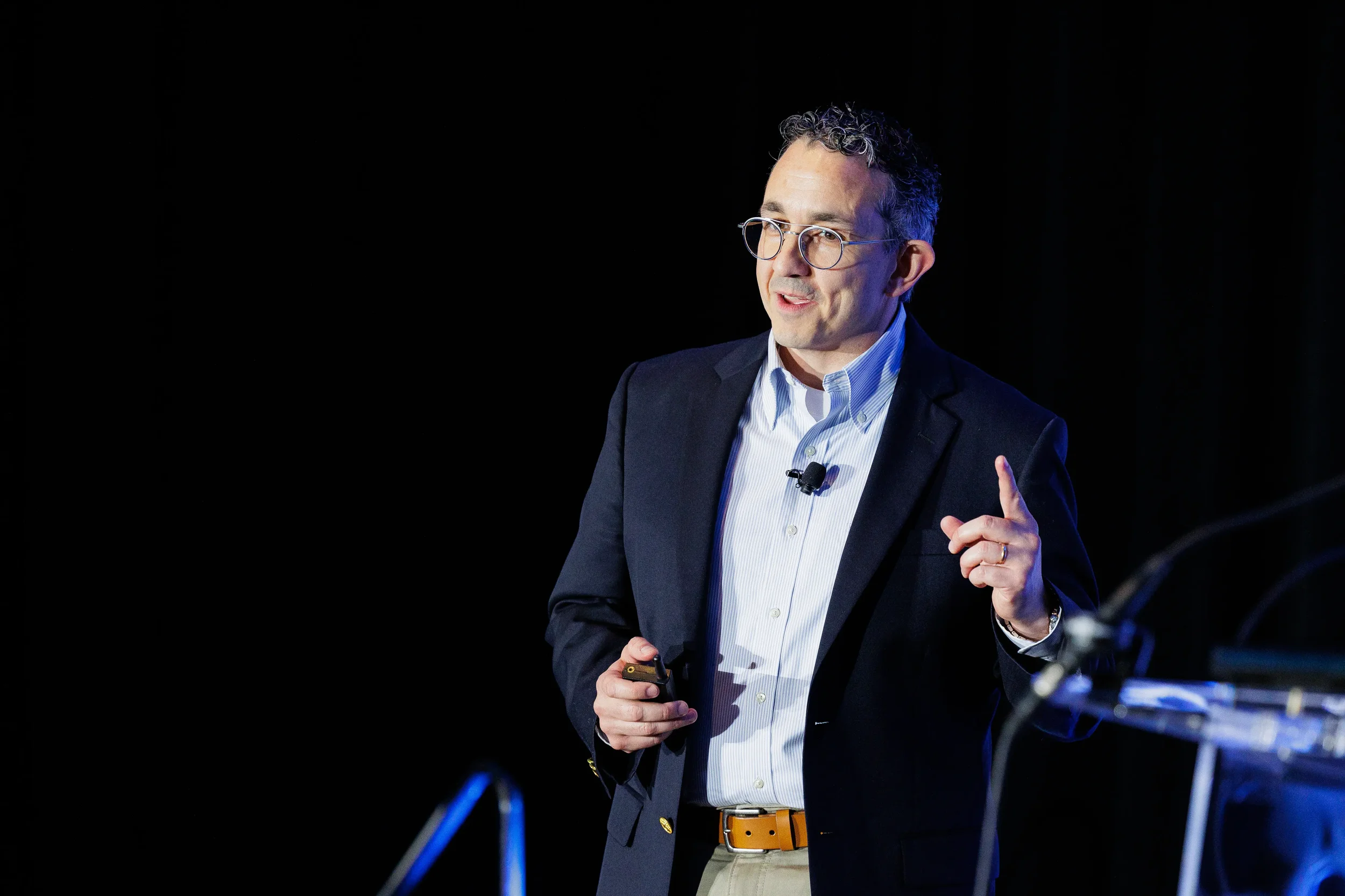 Speaker gestures while presenting on stage at Chicago corporate event