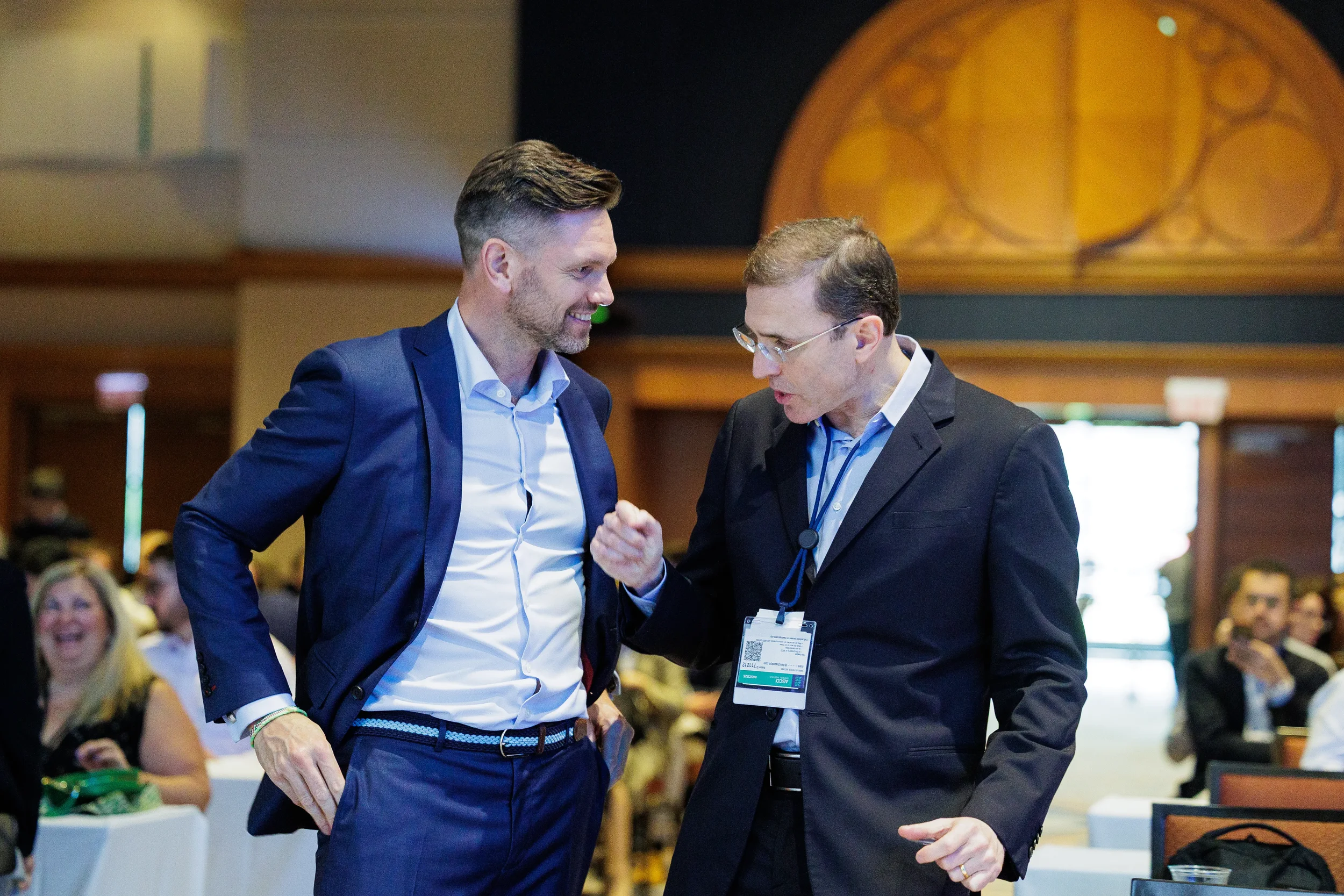Two attendees share a fist bump while conversing at Chicago industry conference reception