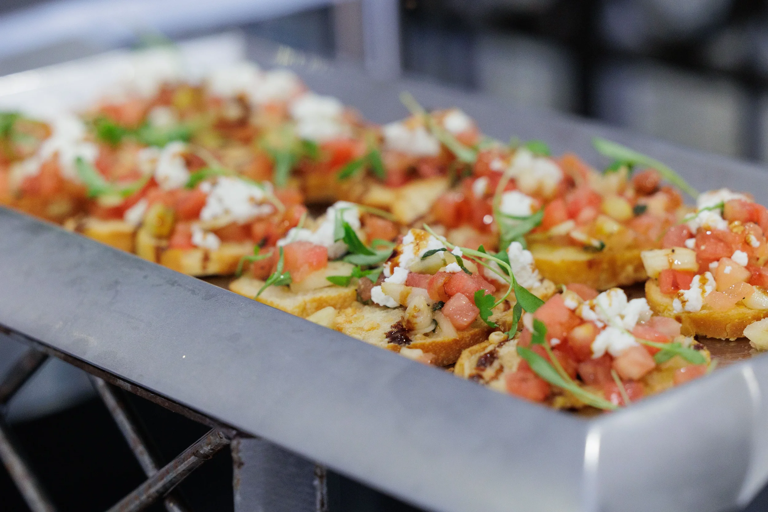 Close-up of bruschetta topped with tomato and feta on catering tray at Orlando corporate event