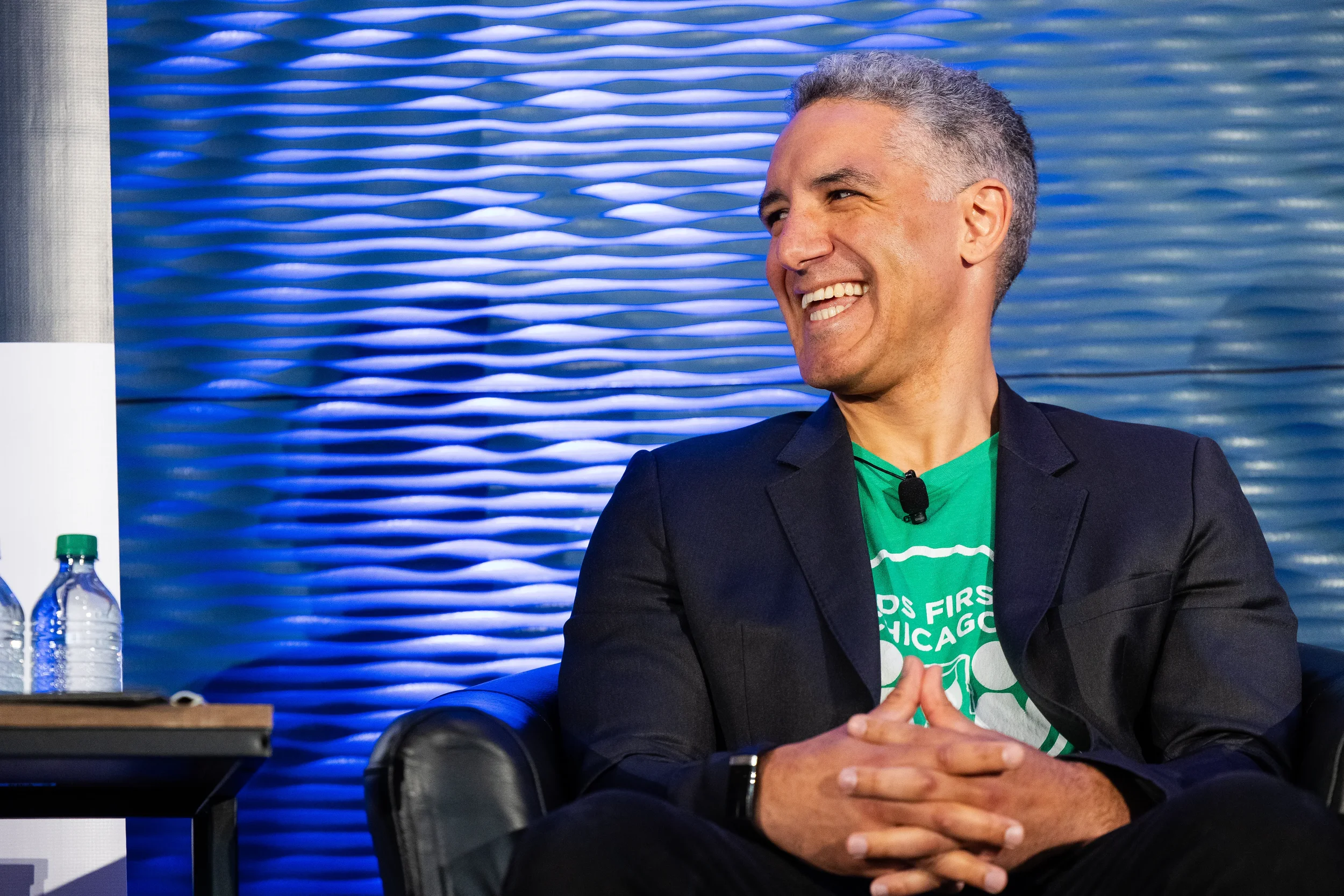 Panelist smiles while seated during fireside chat on stage at Chicago corporate conference