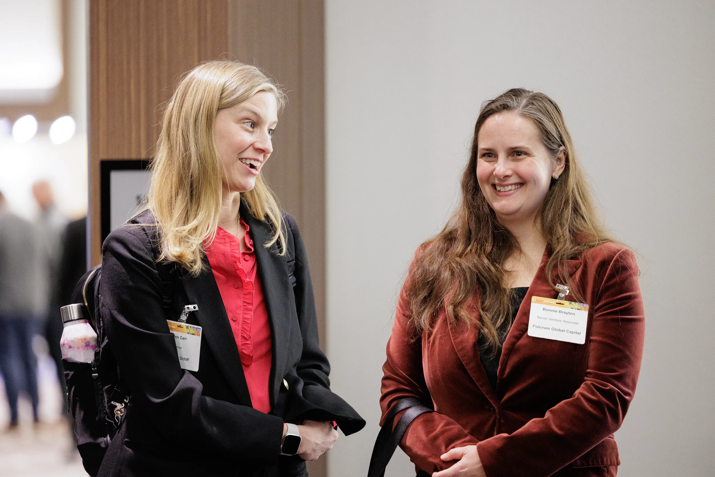 Two attendees smile in conversation during break at Orlando industry conference