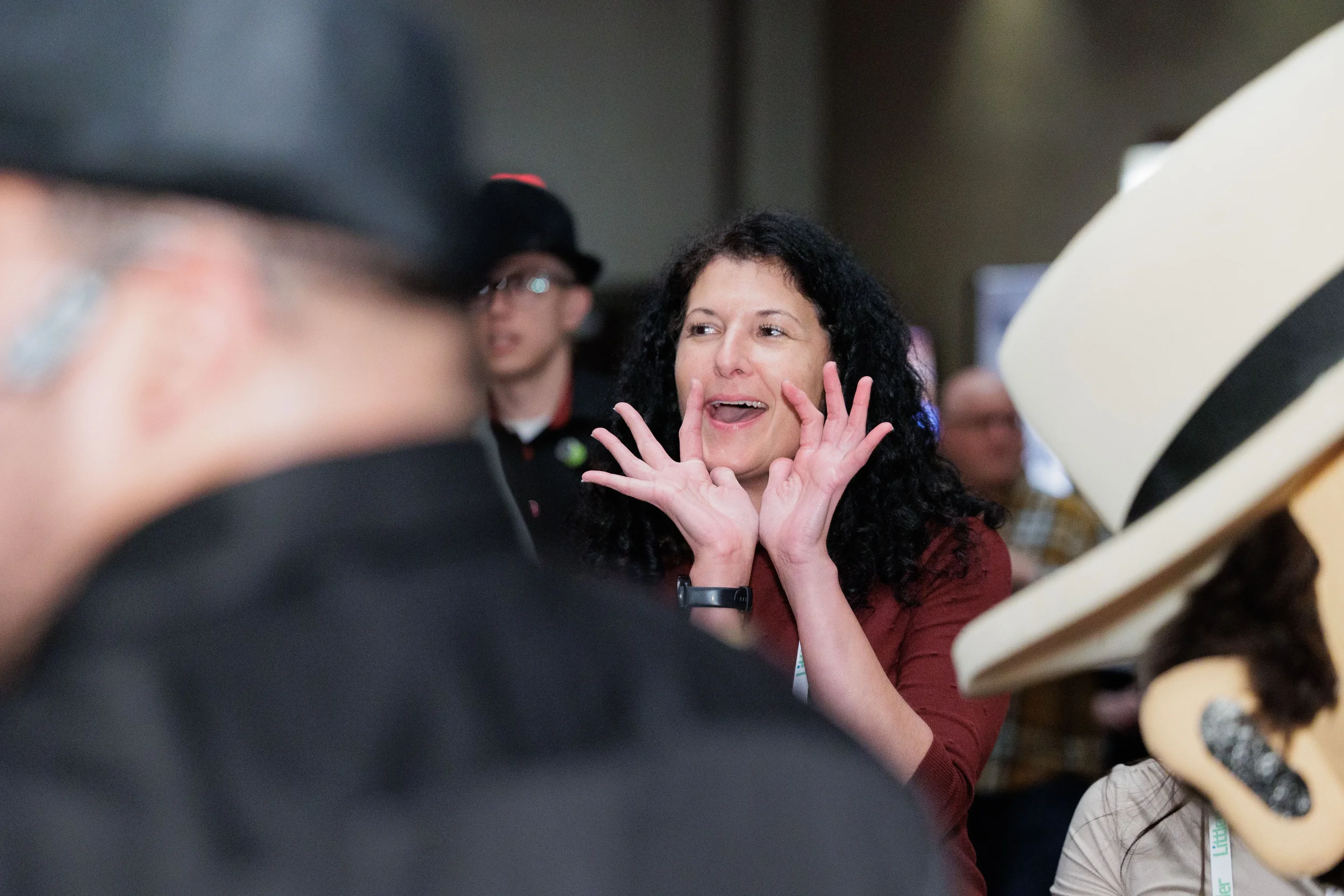 Animated attendee with hands raised mid-expression during lively networking moment at Orlando conference
